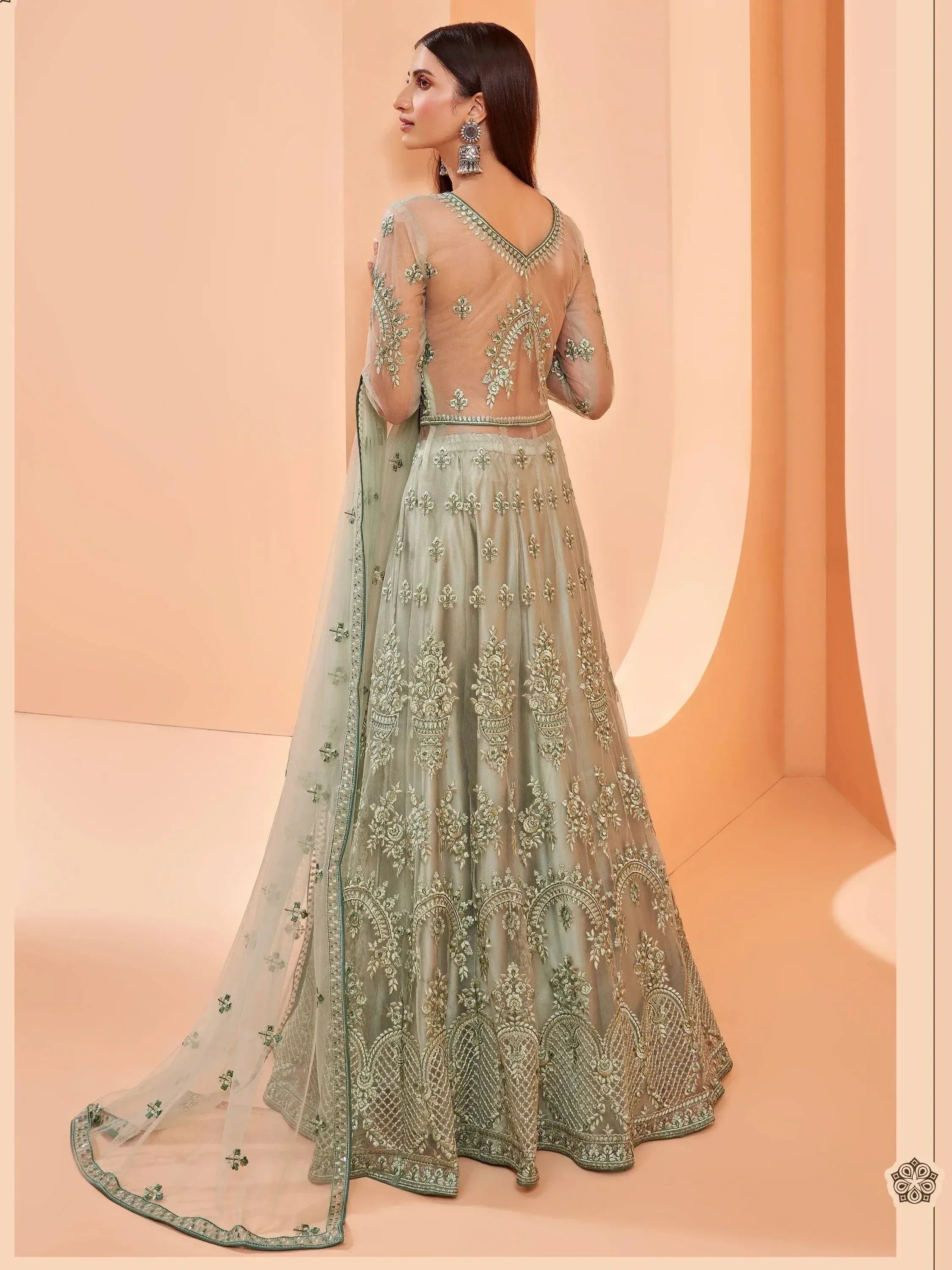 Elegant mint green lehenga choli with intricate gold embroidery and sheer dupatta for Indian ethnic wear