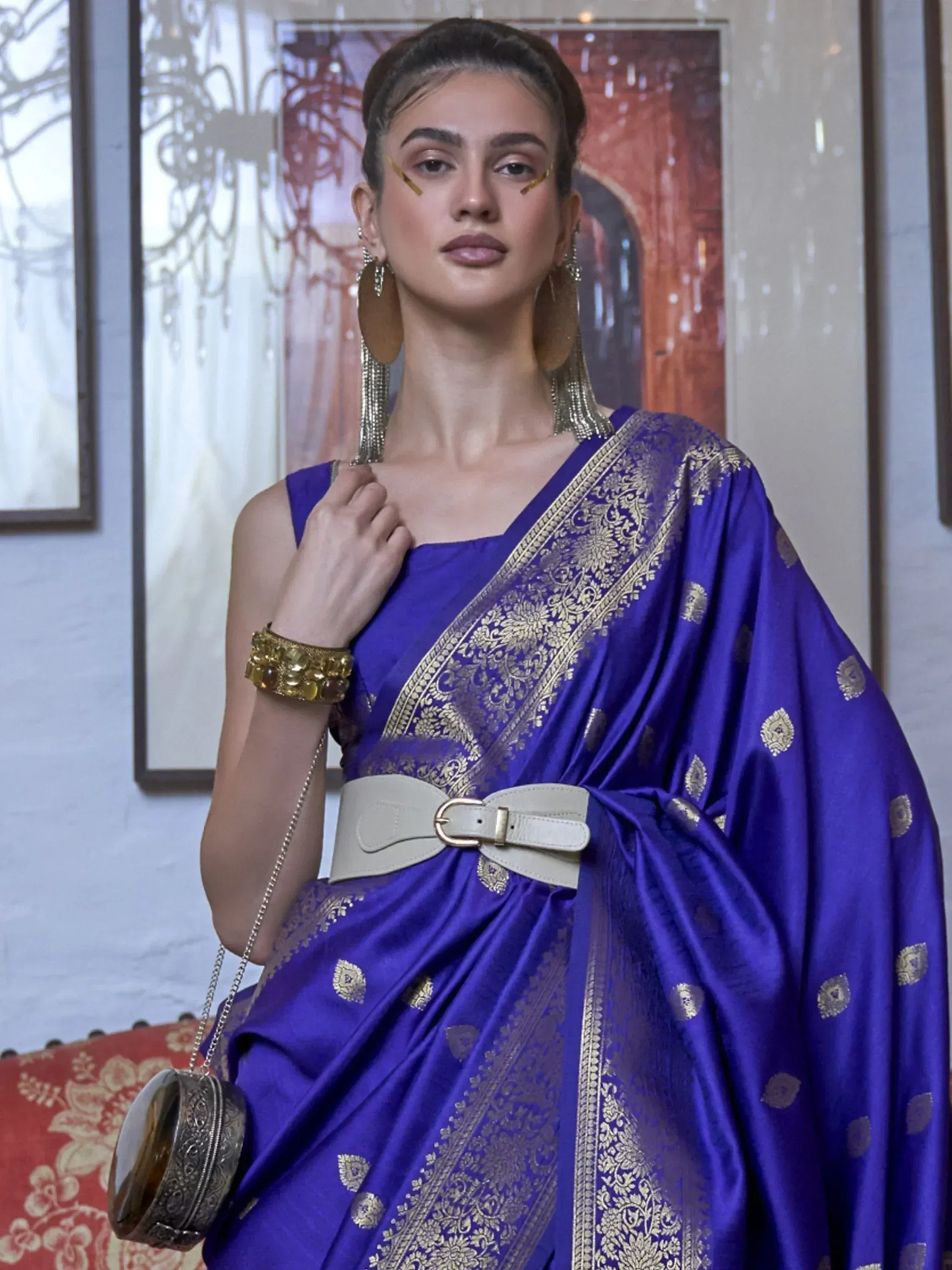 Royal blue silk saree with gold zari work, styled with belt and statement jewelry for ethnic wear
