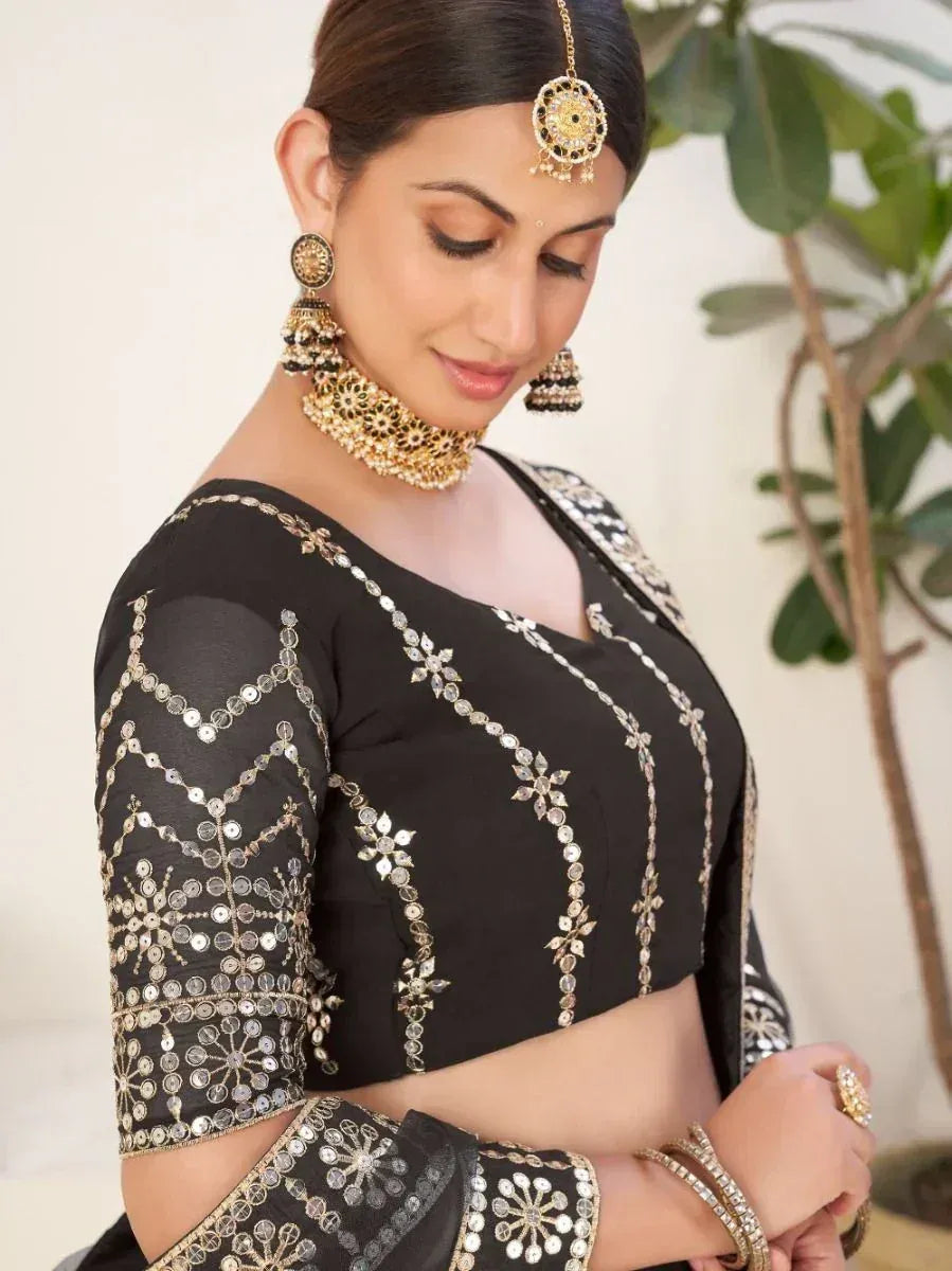Black designer lehenga choli with gold mirror work and traditional Indian jewelry