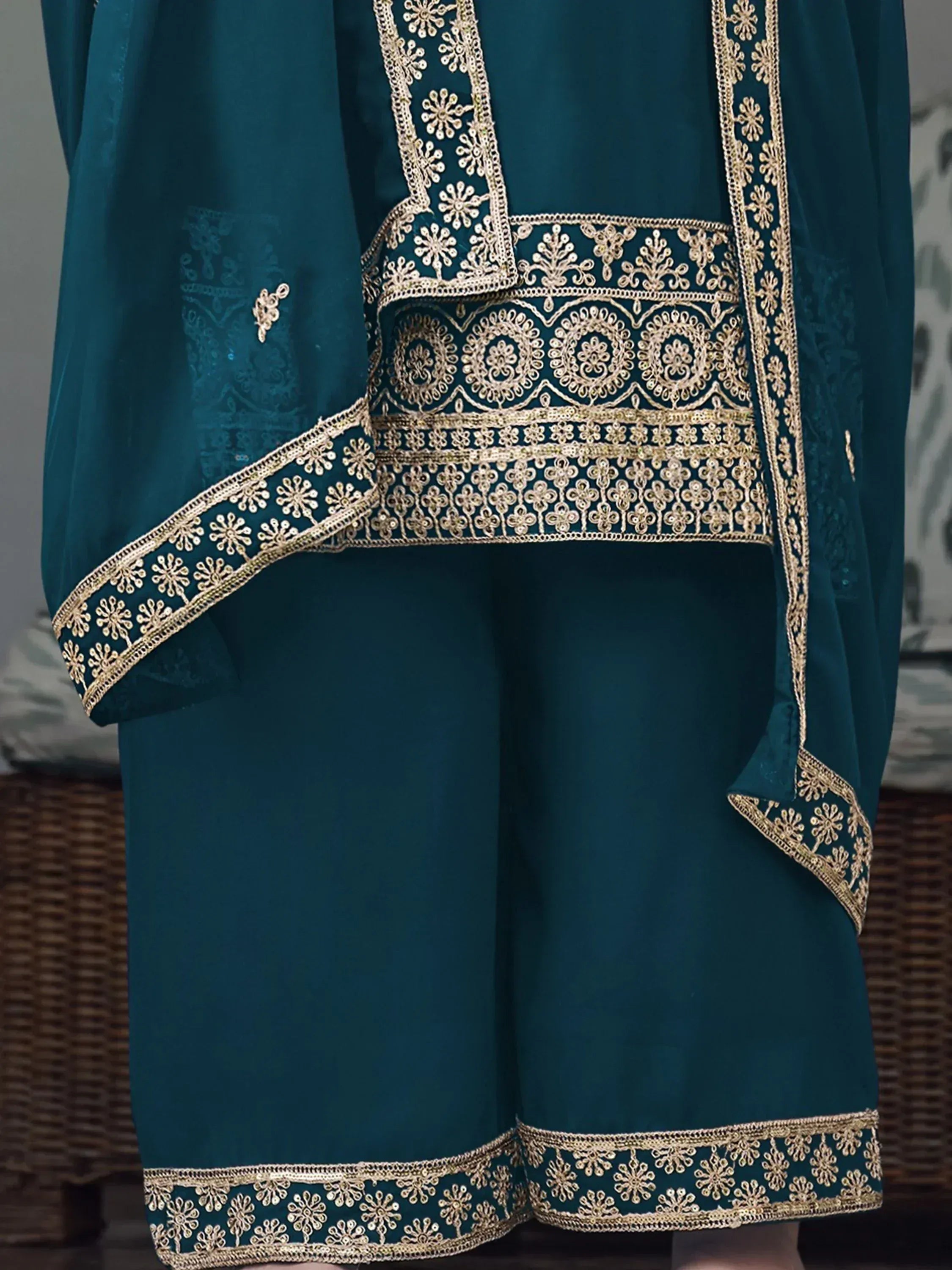 Teal ethnic kurti and pants with intricate gold embroidery and decorative border