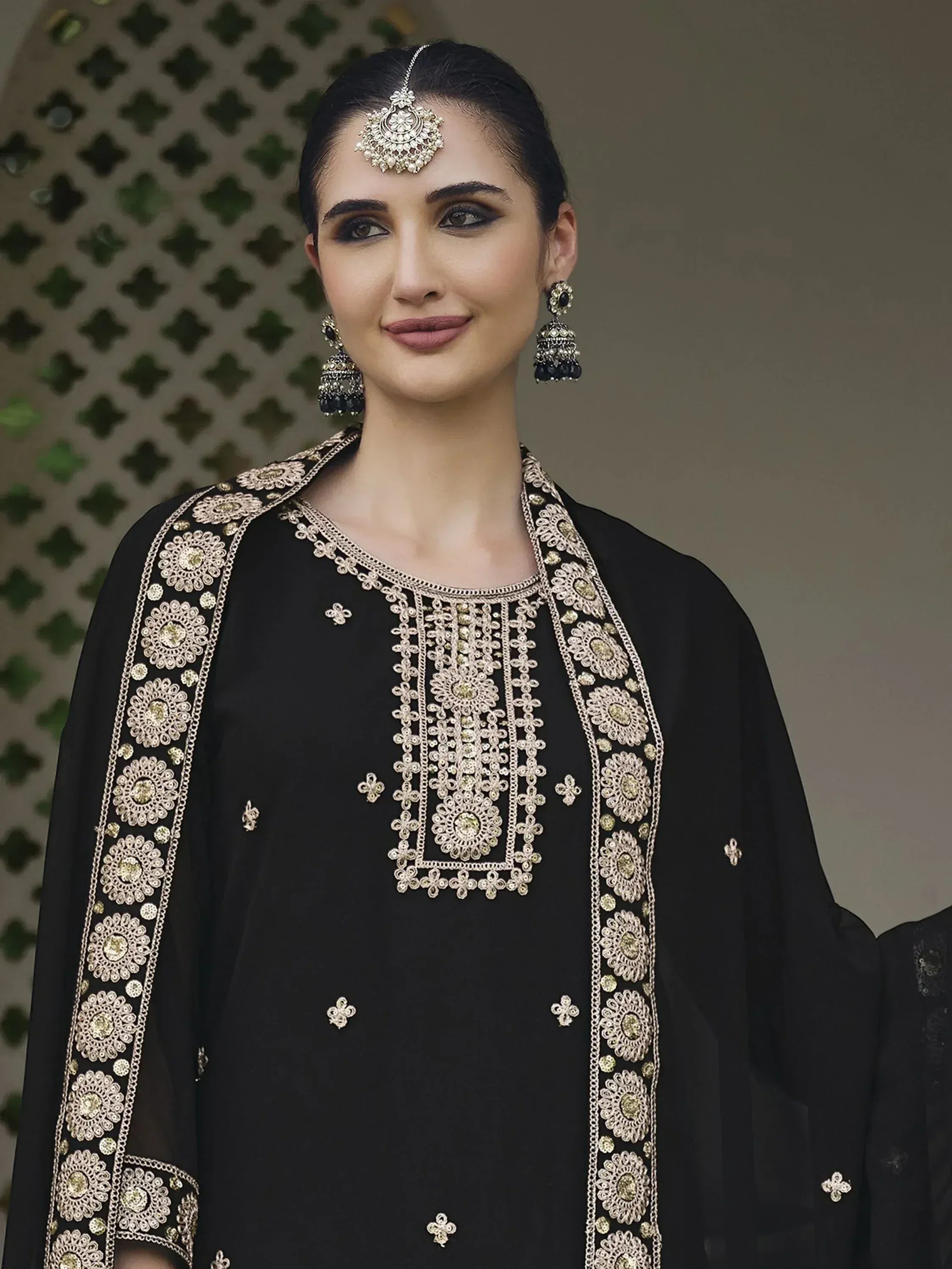 Woman in black embroidered salwar kameez with traditional jewelry, ethnic fashion