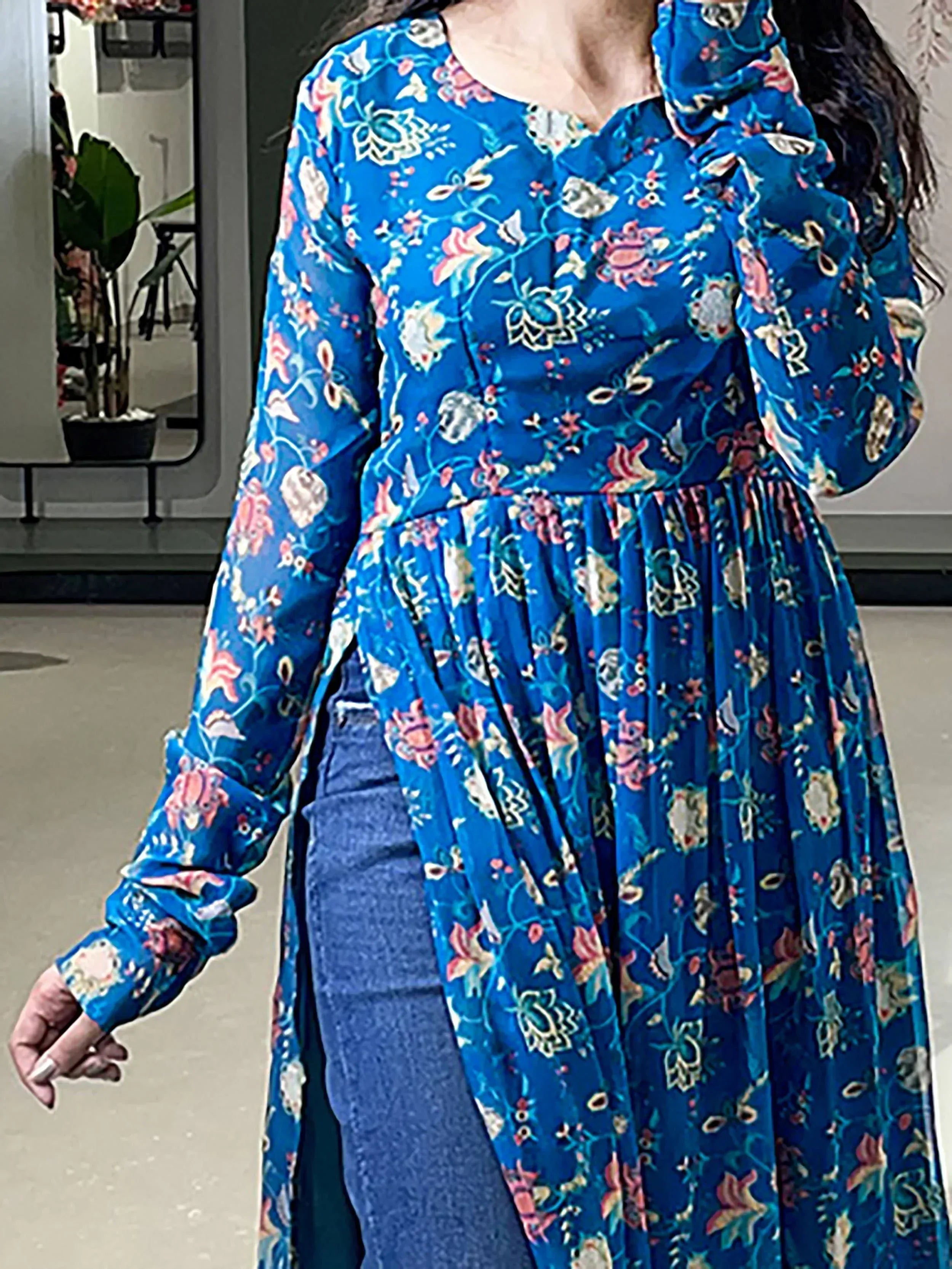 Blue floral printed ethnic kurta with long sleeves and side slit, paired with jeans