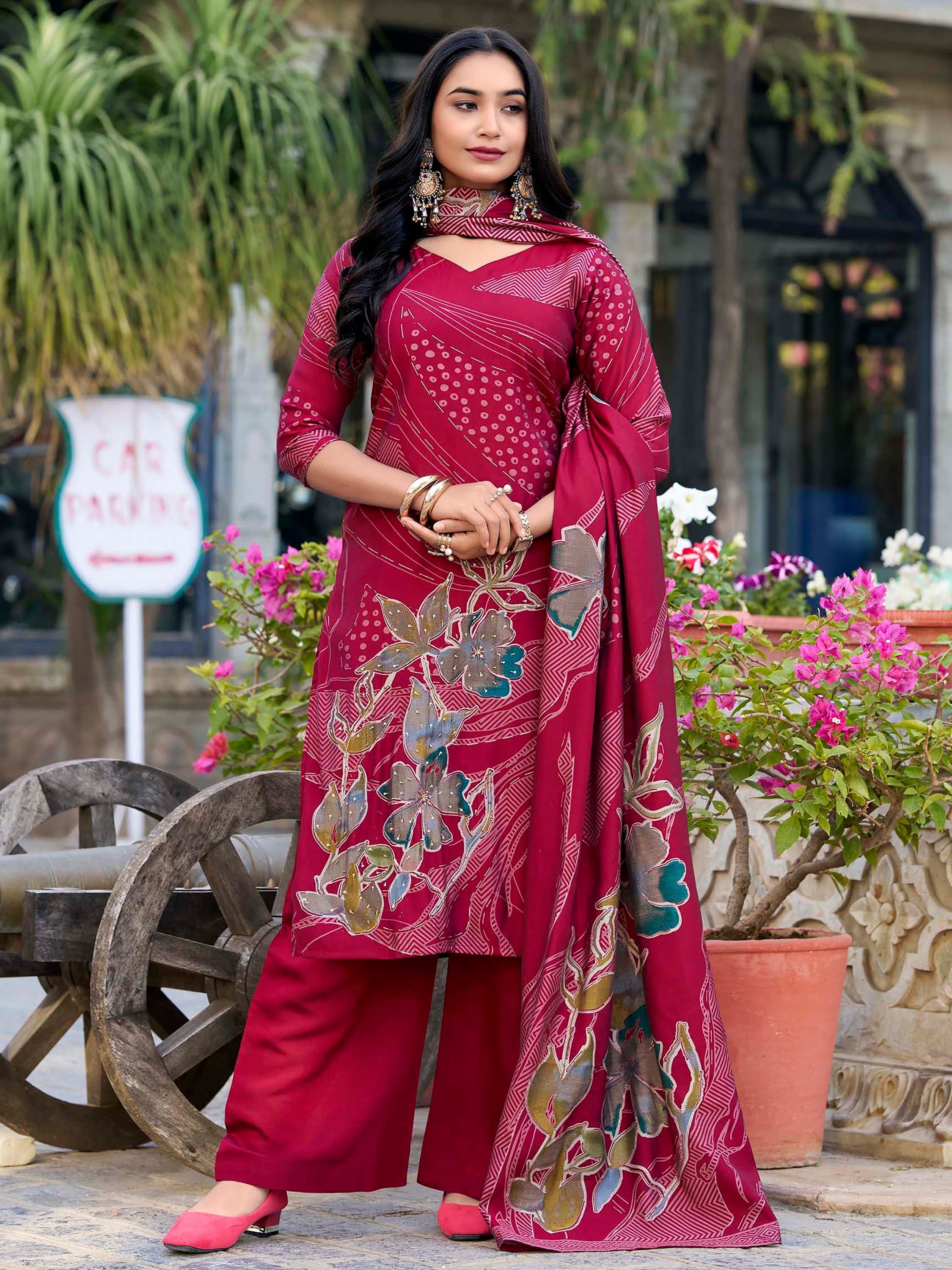 Woman in maroon salwar kameez with floral dupatta, traditional Indian ethnic wear outdoors