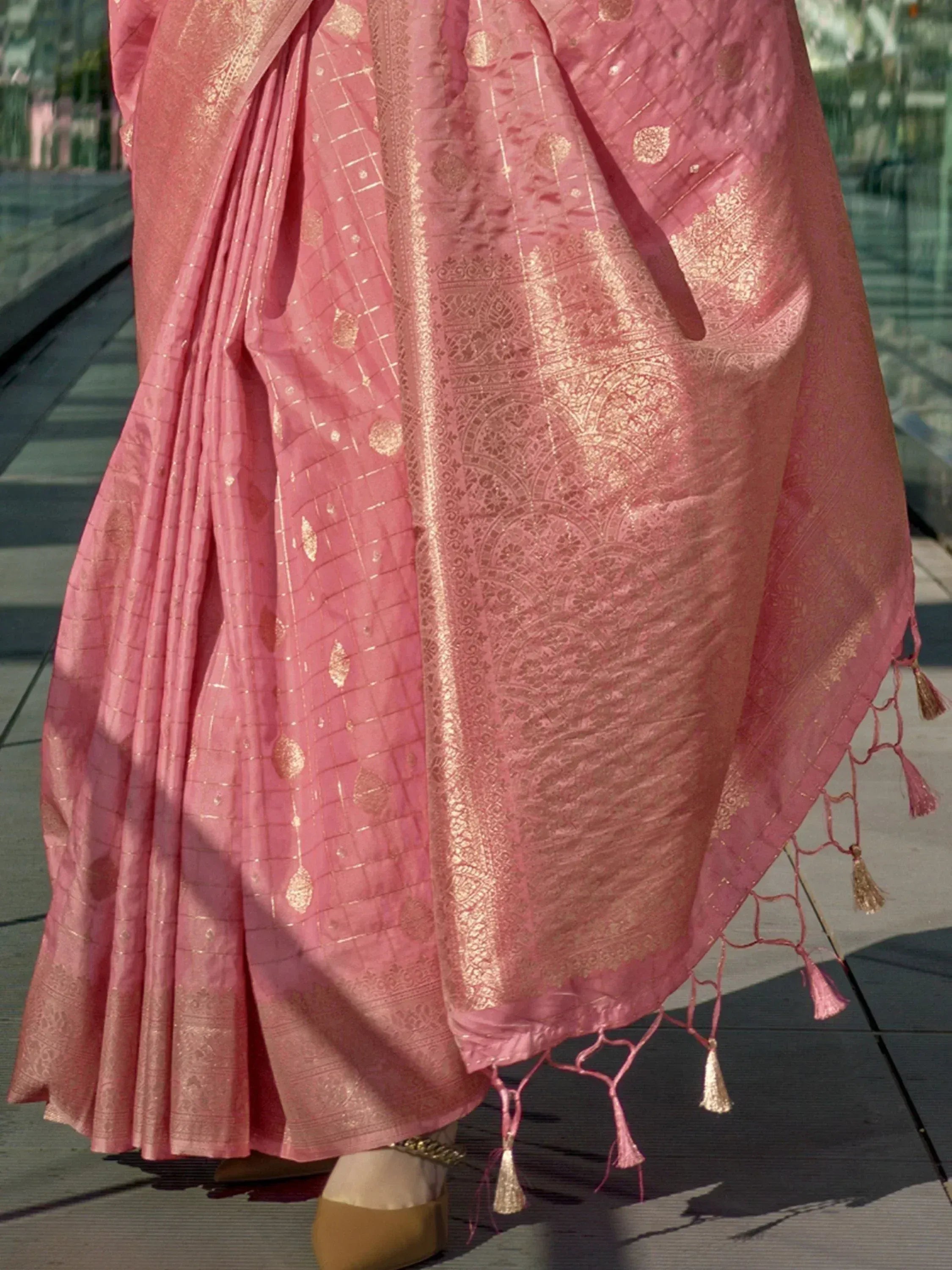 Pink designer saree with gold zari work and tassels, perfect for ethnic occasions