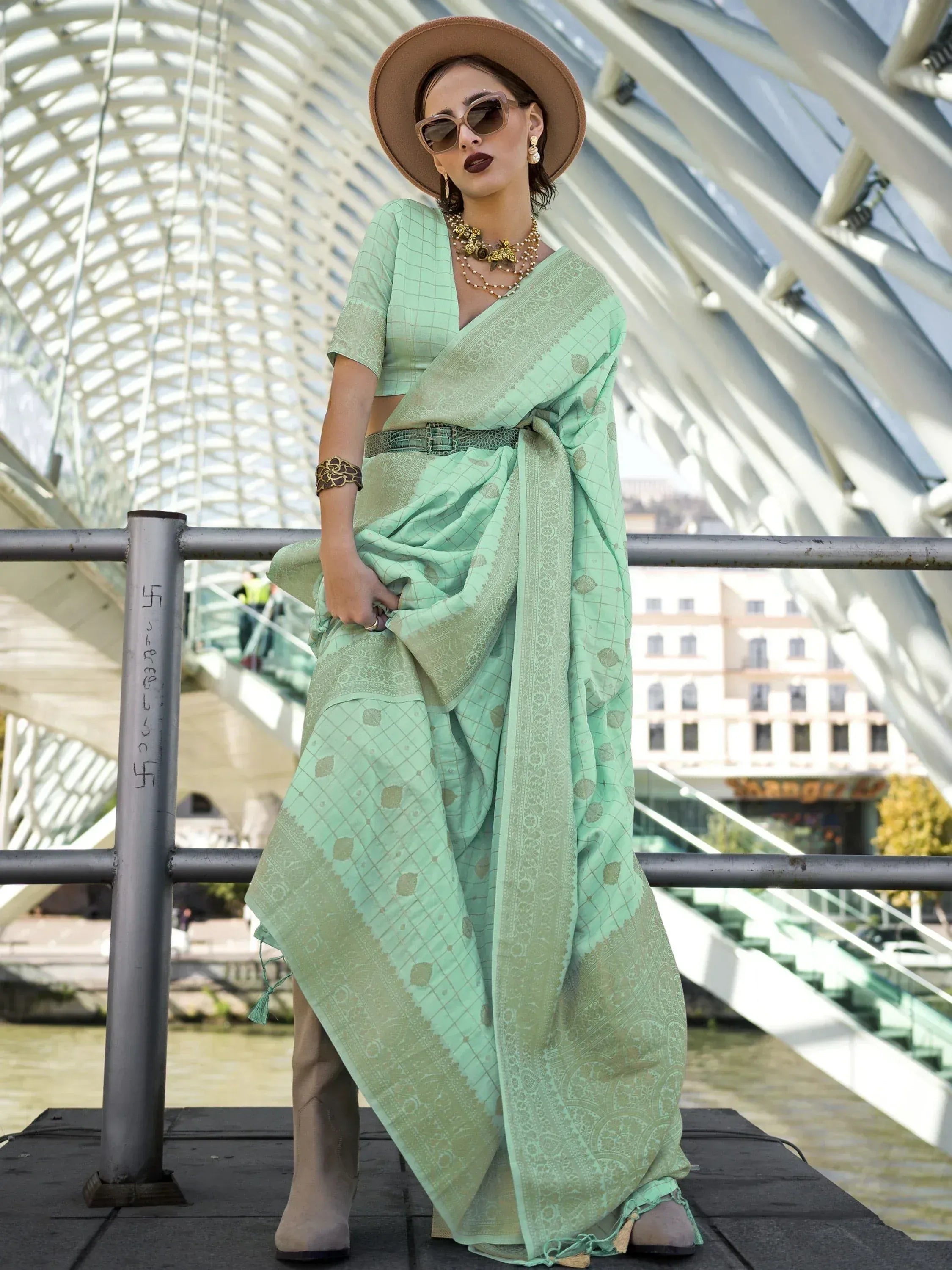 Mint green printed saree with matching blouse, styled with hat and boots for modern ethnic look