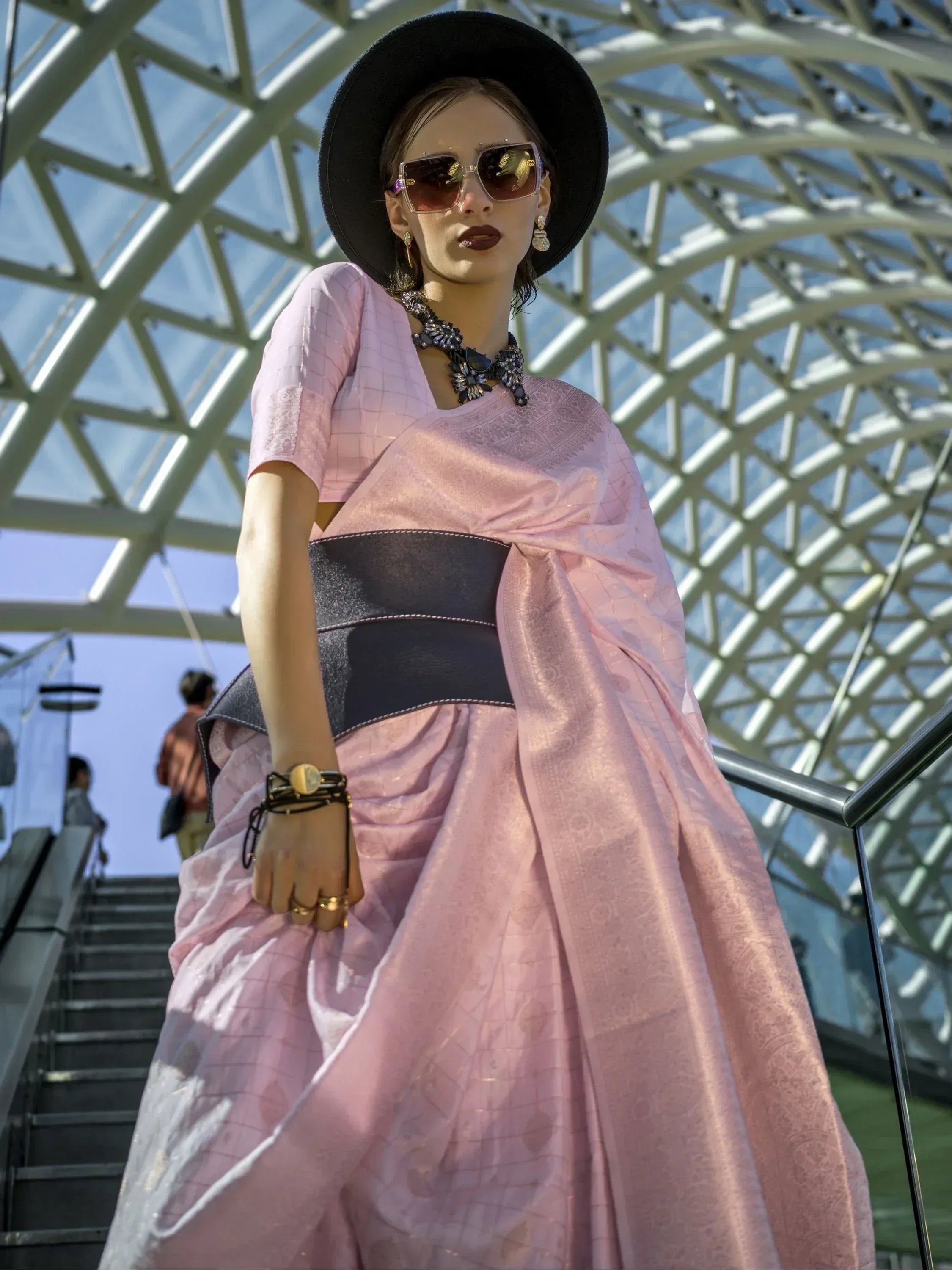 Stylish pink ethnic gown with black belt, hat, and sunglasses for modern Indian fashion