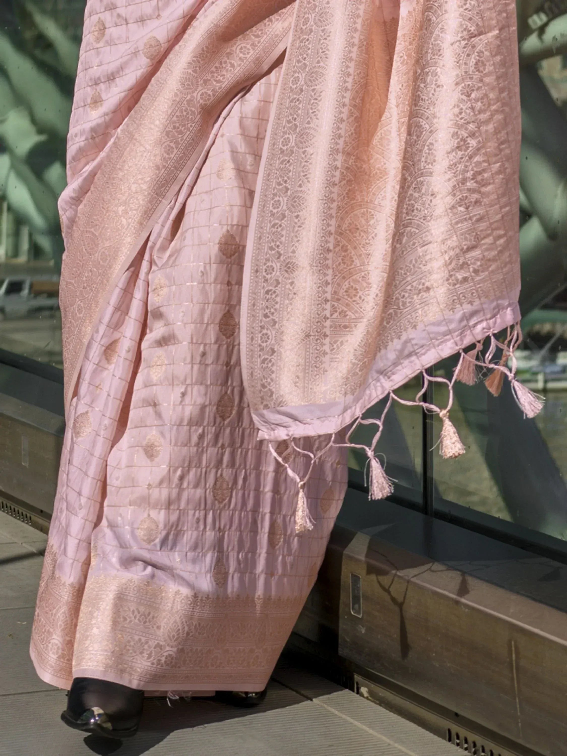 Pink designer saree with gold zari work, tassels, and intricate border for ethnic wear