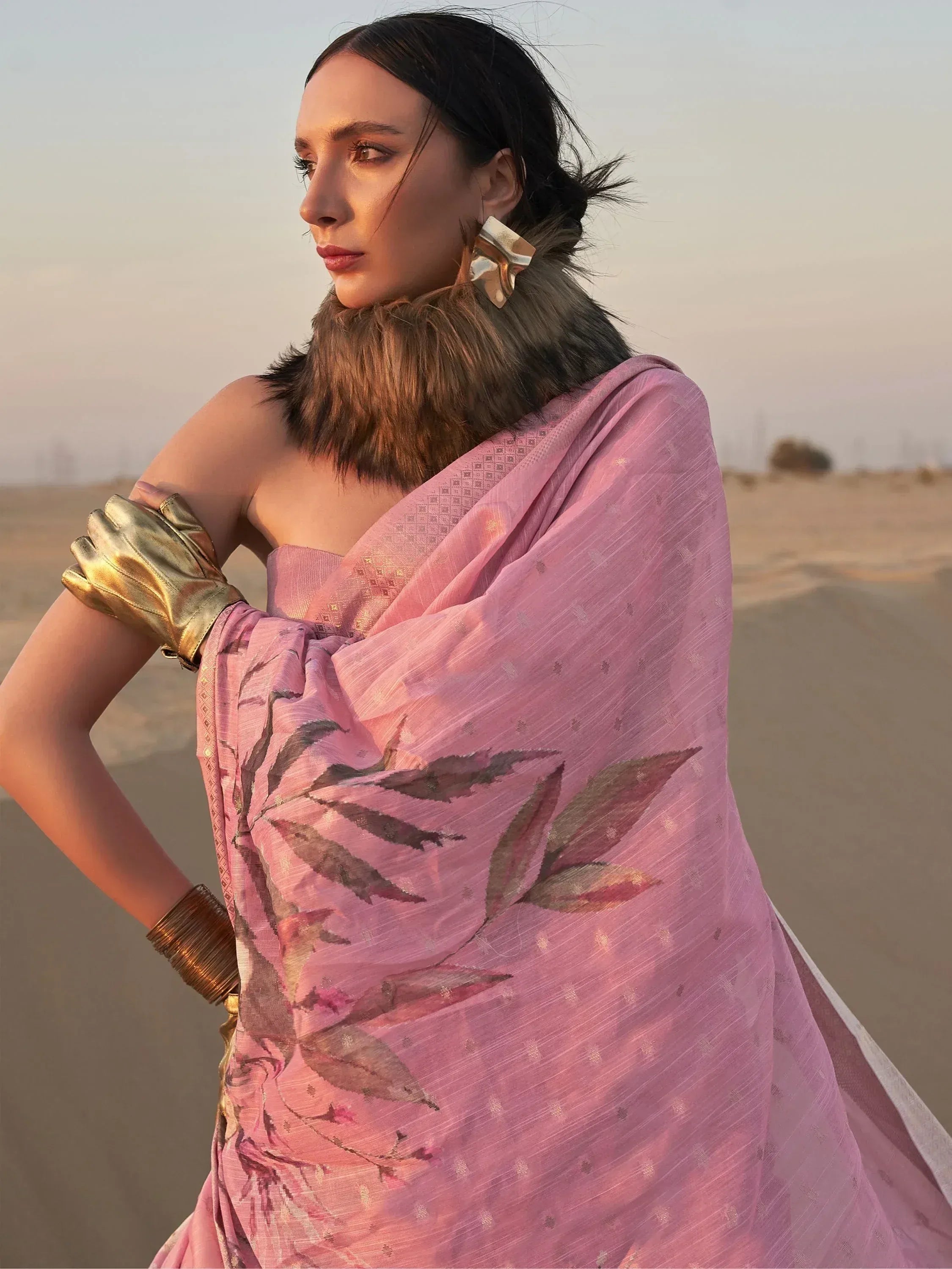 Pink floral ethnic gown with fur collar, gold gloves, desert sunset backdrop