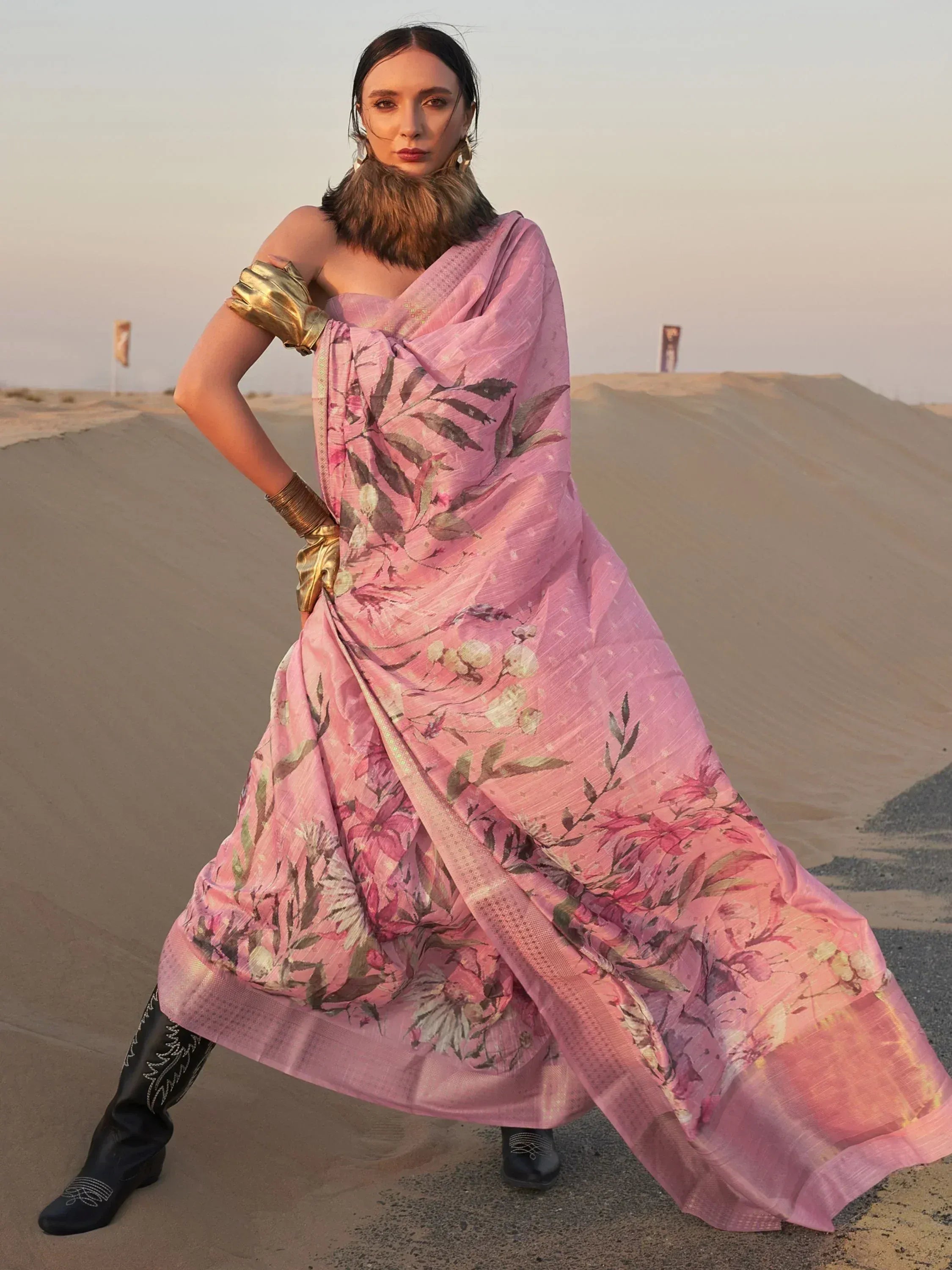Pink floral printed saree with gold accents, styled with boots and fur collar in desert setting