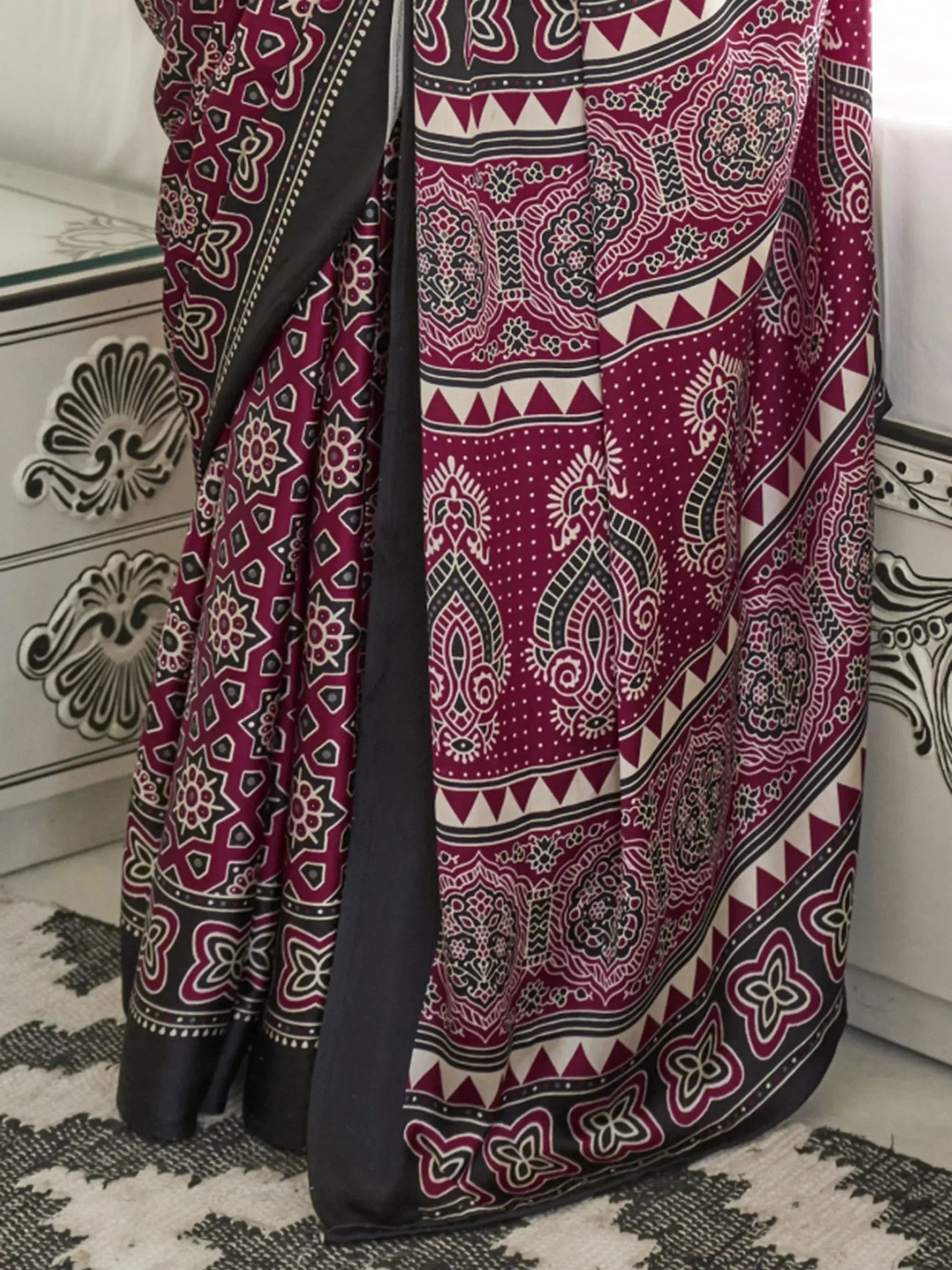 Maroon and black printed ethnic saree with intricate paisley and geometric patterns, perfect for traditional occasions.