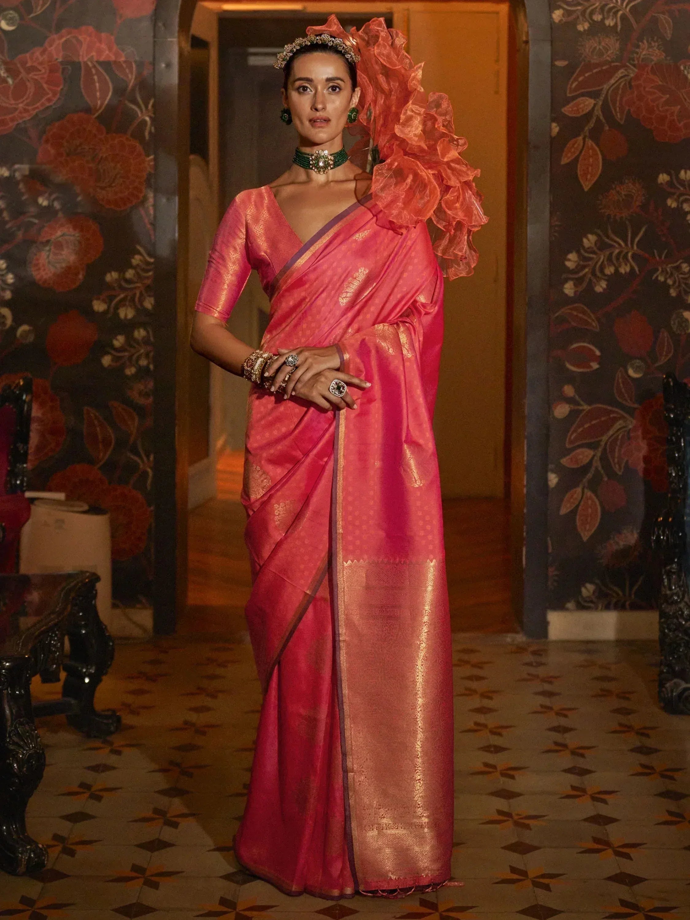 Woman in vibrant pink designer saree with gold zari, ruffled dupatta, and traditional jewelry for ethnic wear