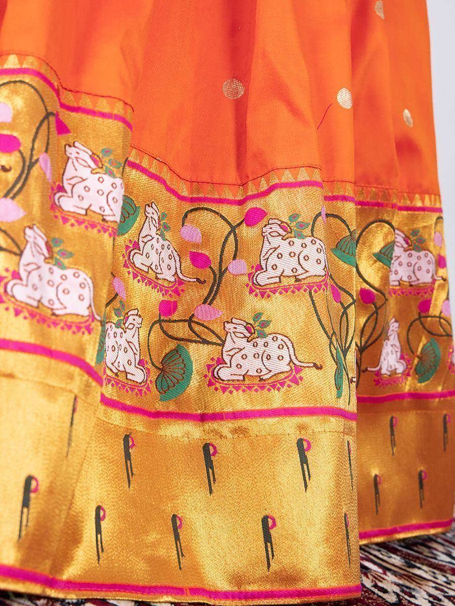 Vibrant orange ethnic skirt with golden border, embroidered deer and floral motifs, perfect for Indian festive wear.
