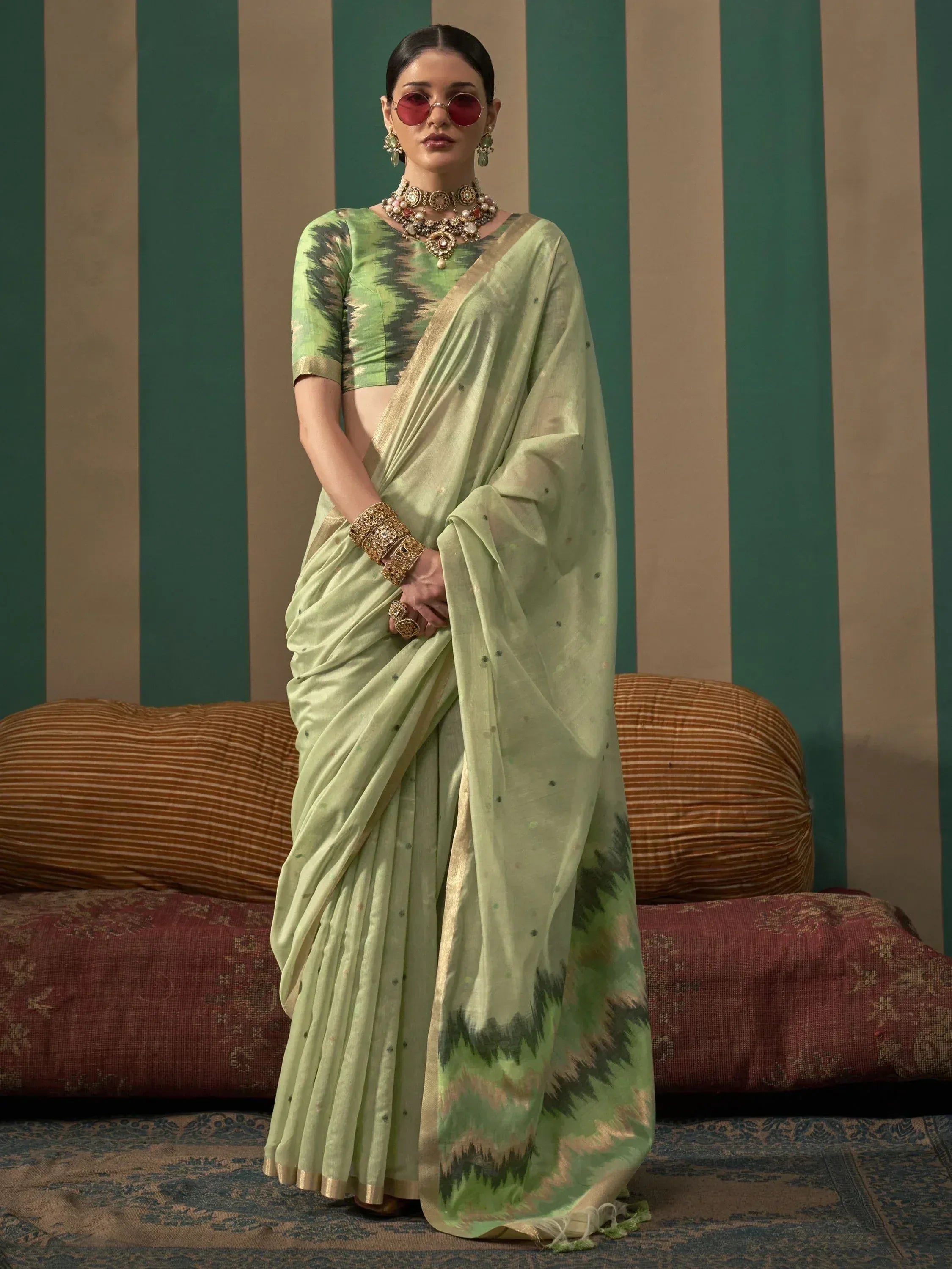 Light green ikat saree with gold border, paired with matching blouse and traditional jewelry for ethnic wear