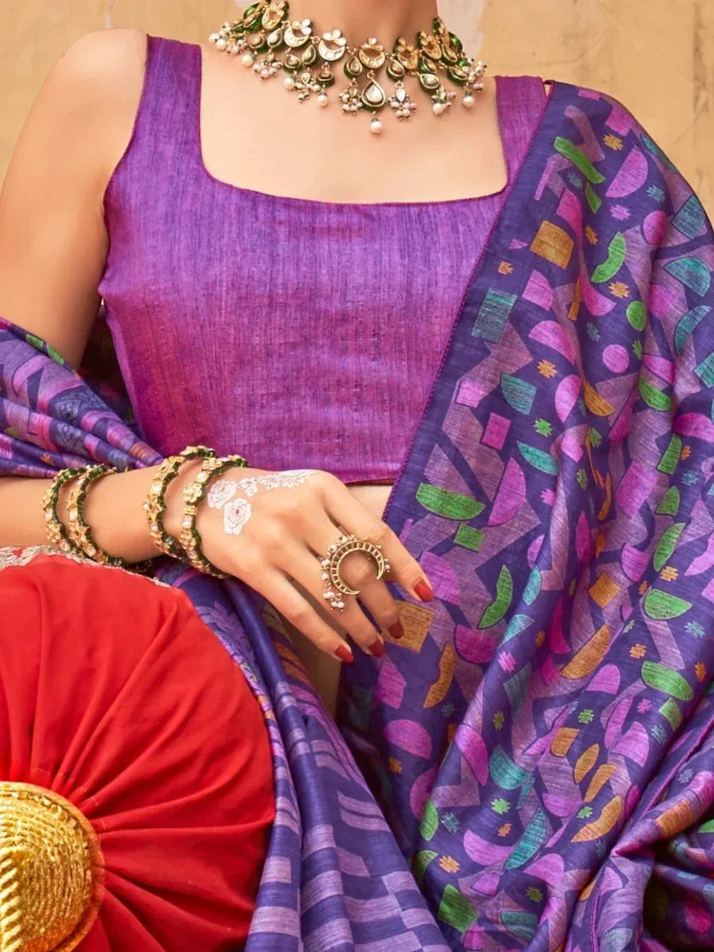 Purple ethnic saree with geometric print, paired with sleeveless blouse and traditional jewelry for festive occasions