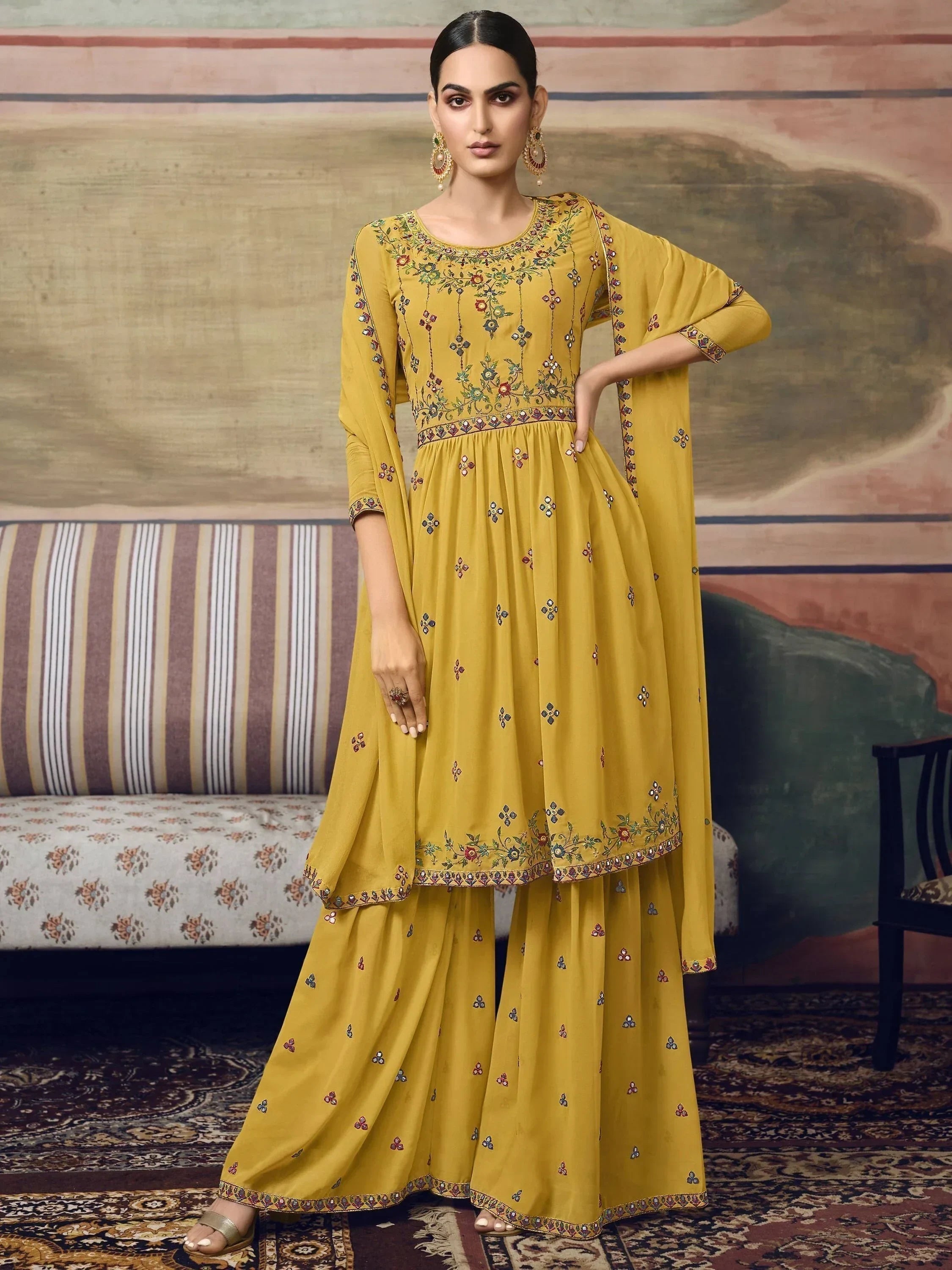 Woman wearing mustard yellow embroidered ethnic palazzo suit with dupatta, traditional Indian attire