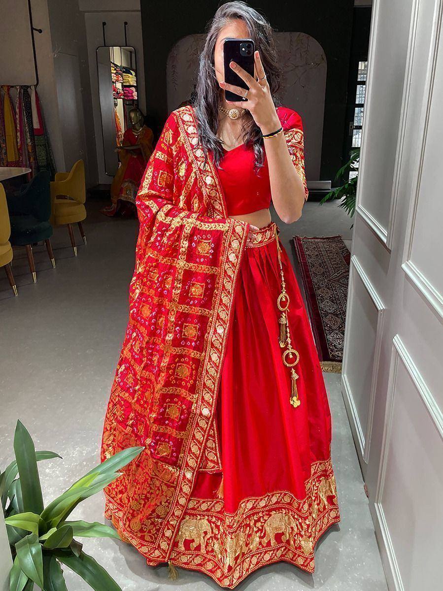 Red designer lehenga choli with gold embroidery, perfect for Indian weddings and festive occasions.