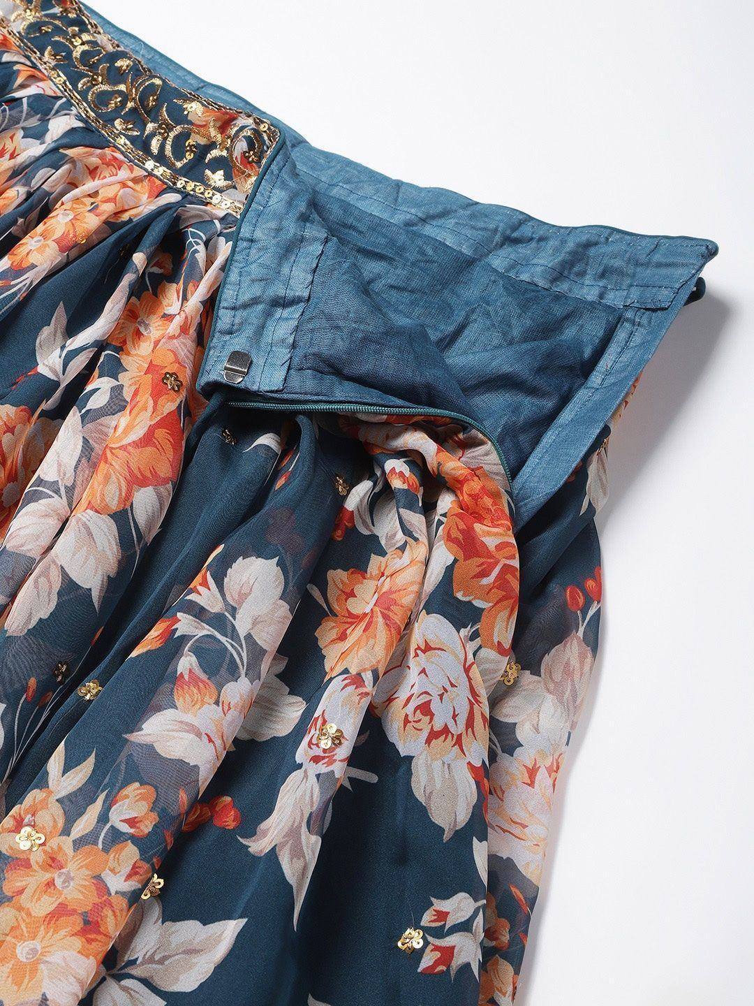 Floral print ethnic gown with gold embroidery and blue waistband, perfect for Indian occasions