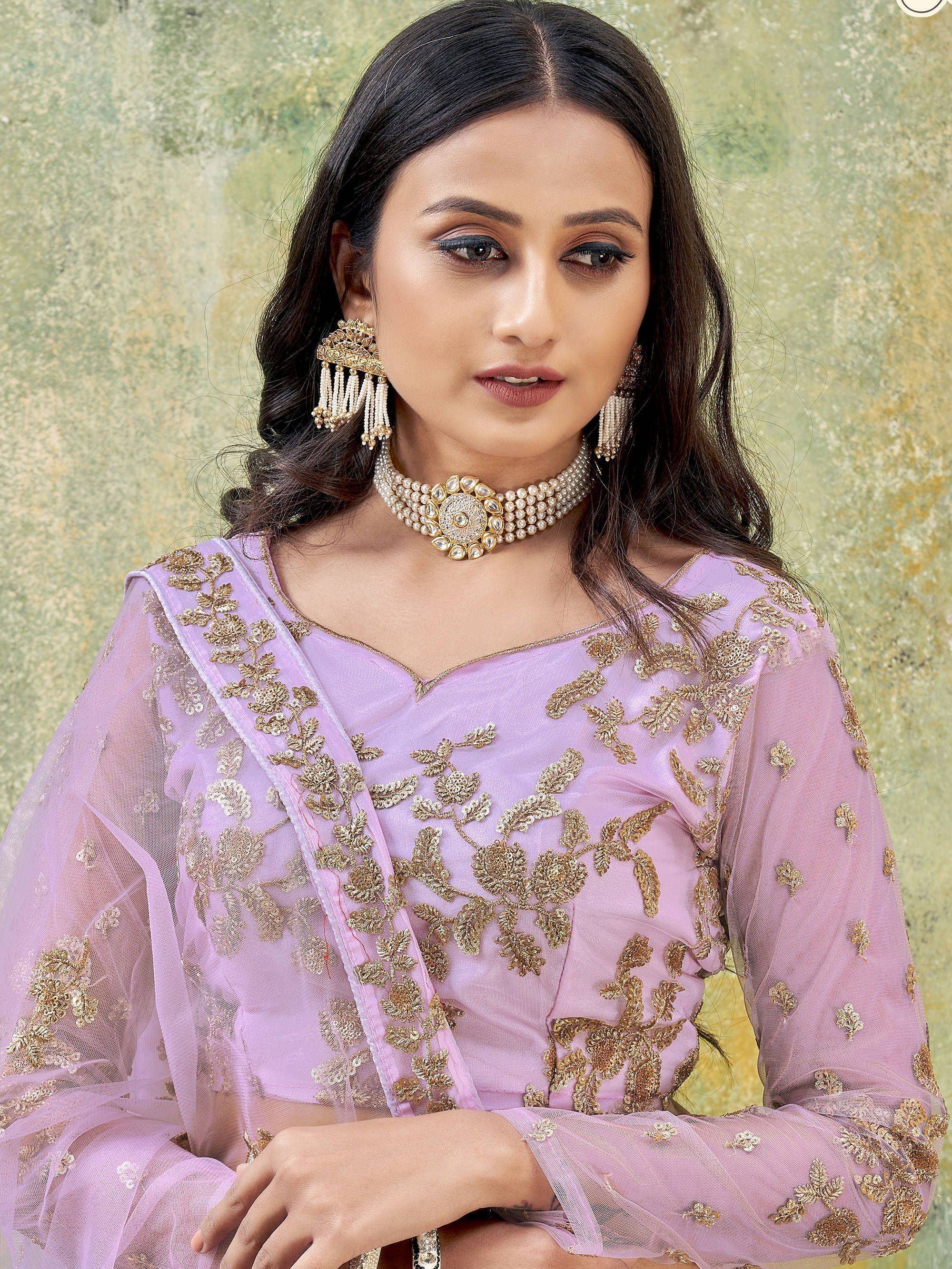 Lavender ethnic gown with gold floral embroidery, paired with pearl and gold jewelry for festive occasions.