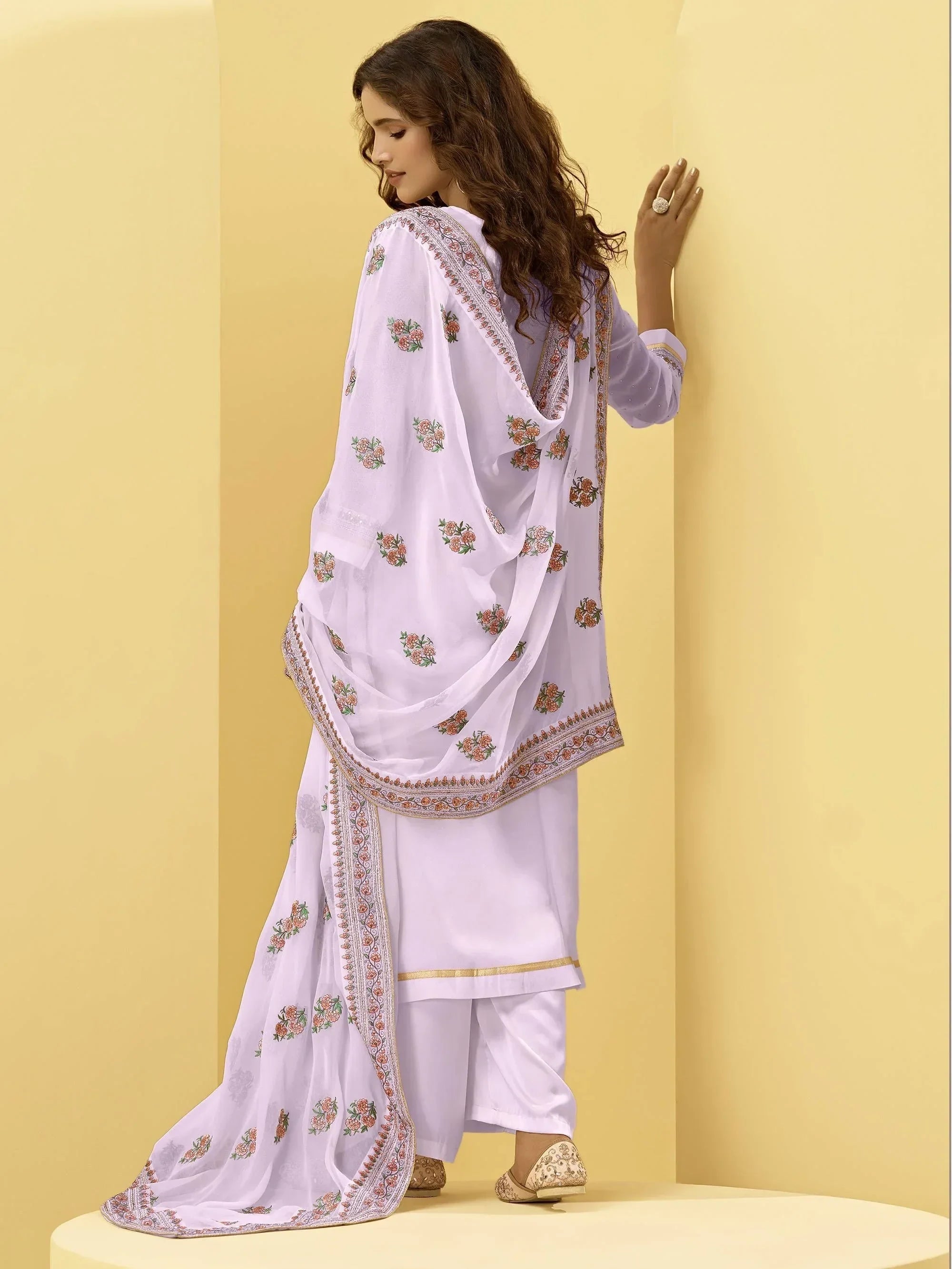 Woman in light purple embroidered salwar kameez with floral dupatta, traditional Indian attire