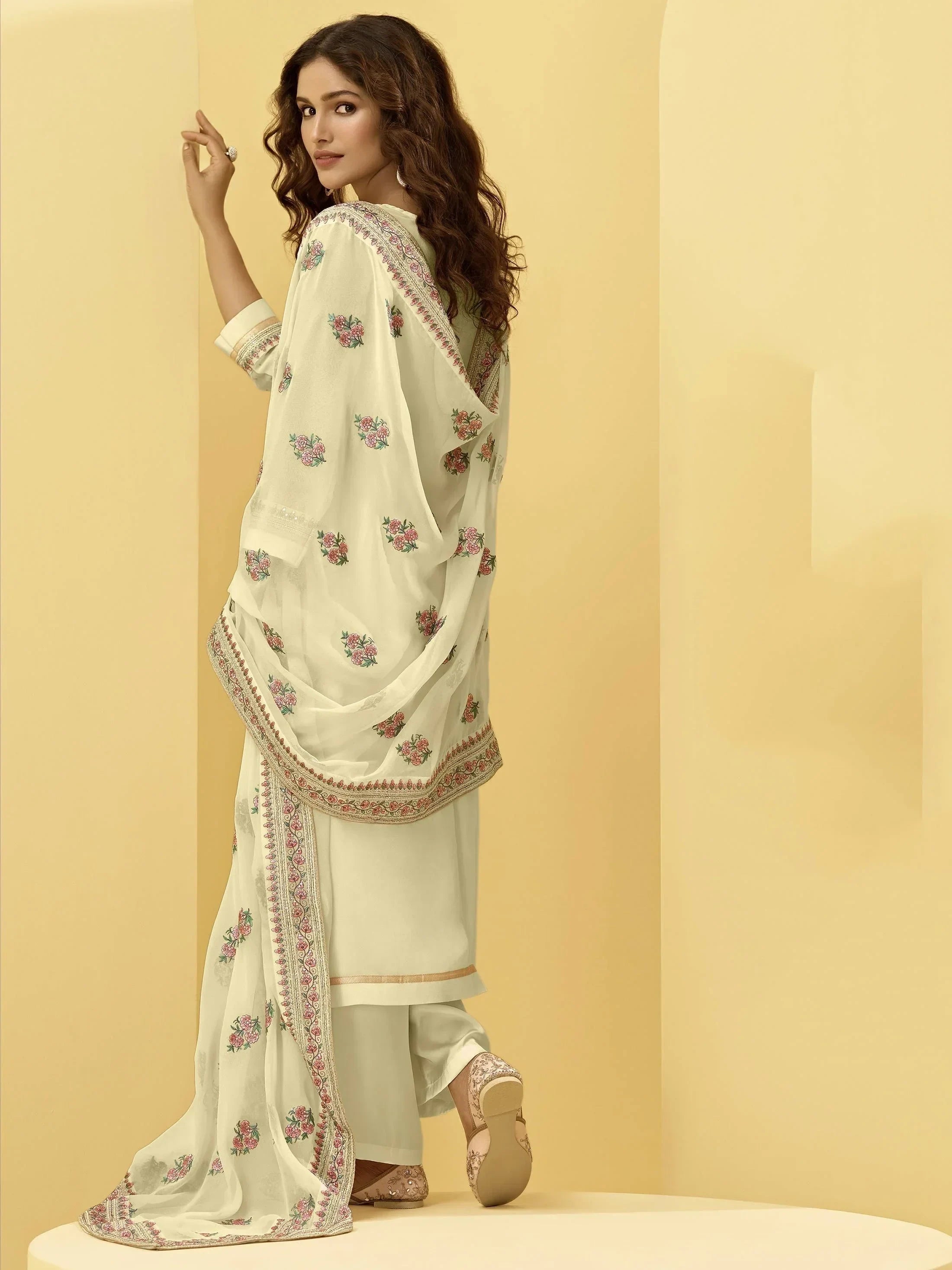 Woman in cream embroidered salwar kameez with floral dupatta, traditional Indian attire