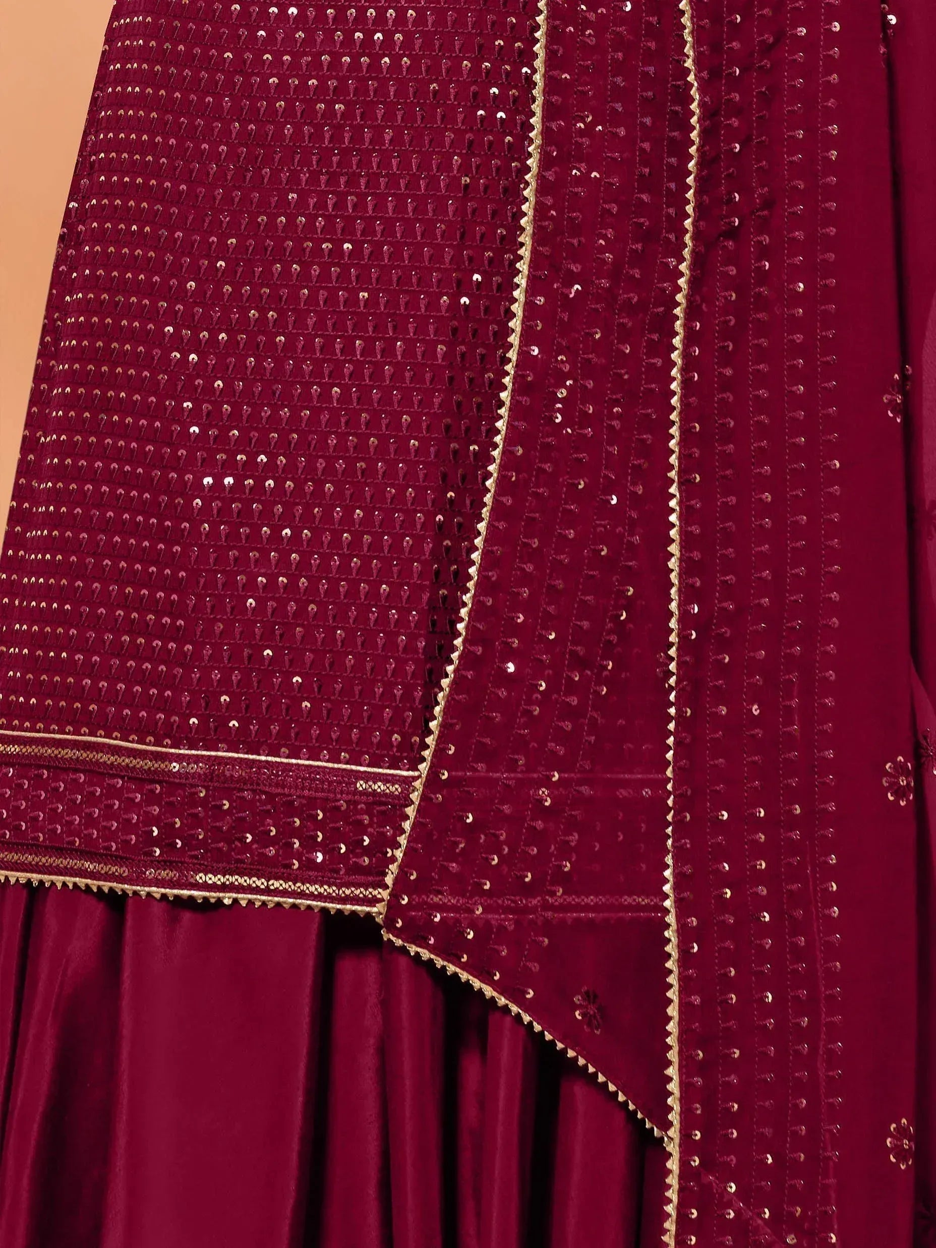 Rich maroon velvet lehenga choli with intricate gold sequin embroidery and detailed border work