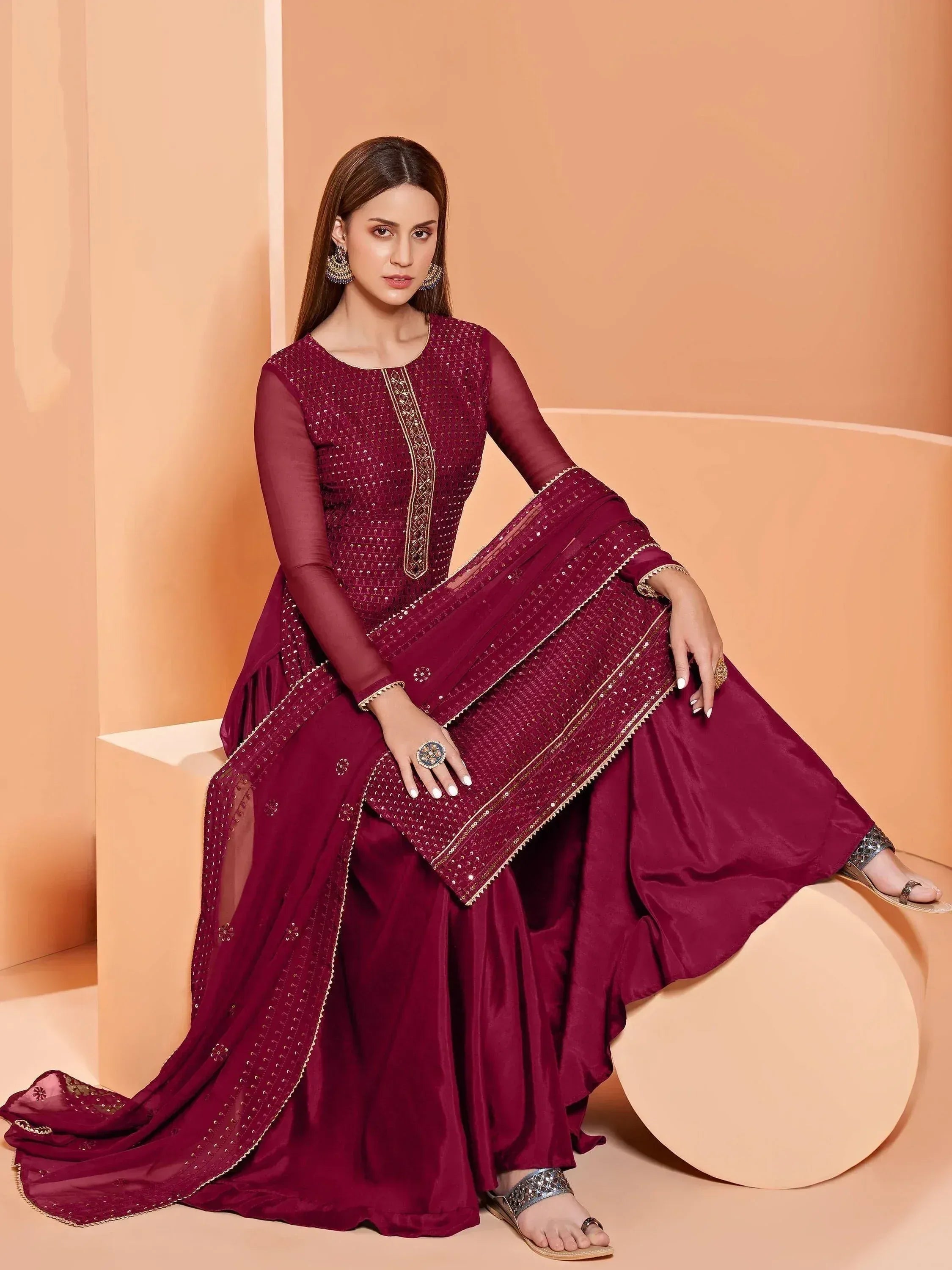 Elegant maroon ethnic salwar kameez with gold embroidery and sheer dupatta, perfect for festive occasions.