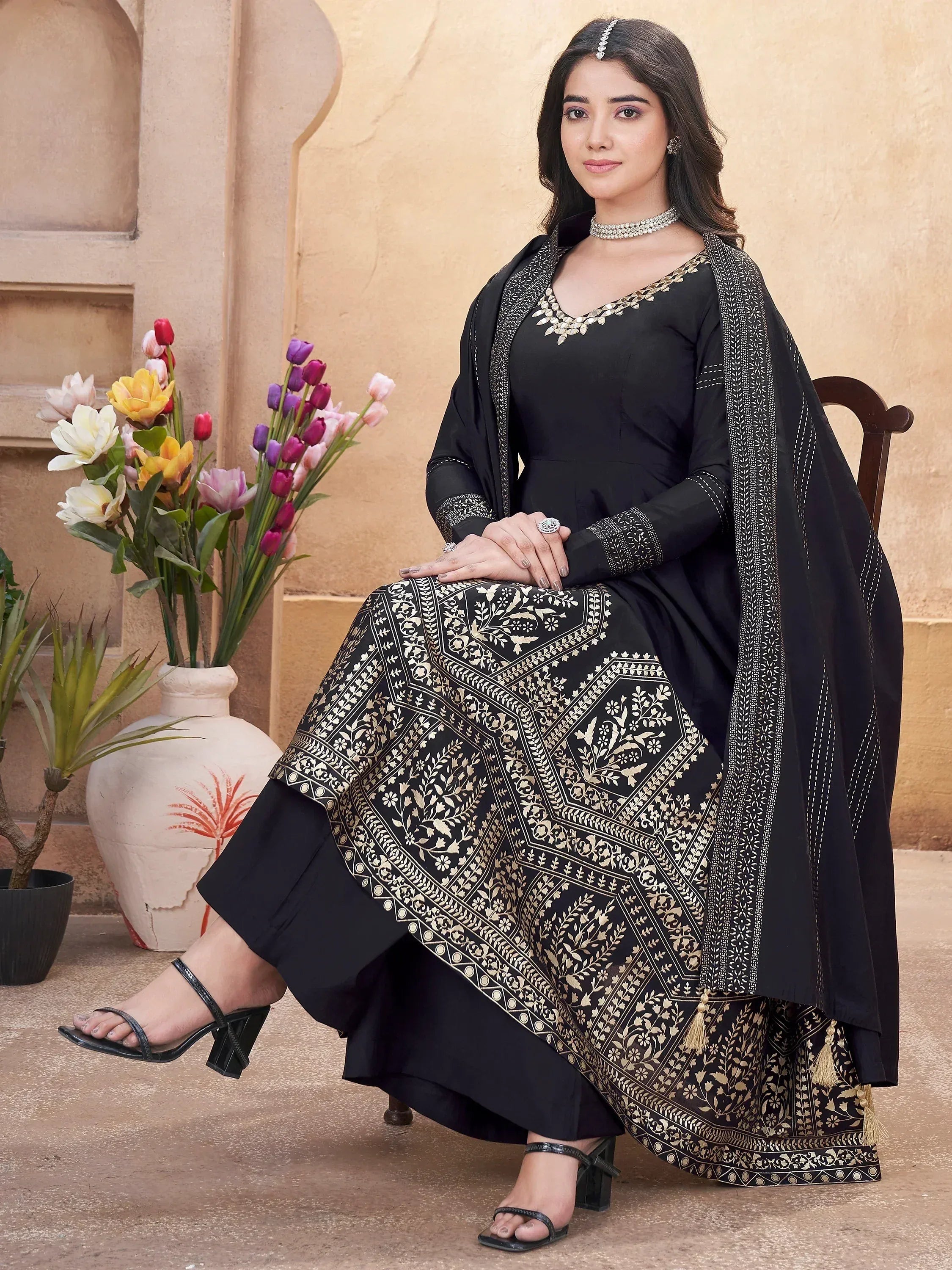 Black embroidered ethnic gown with gold floral print, paired with matching dupatta and palazzo pants