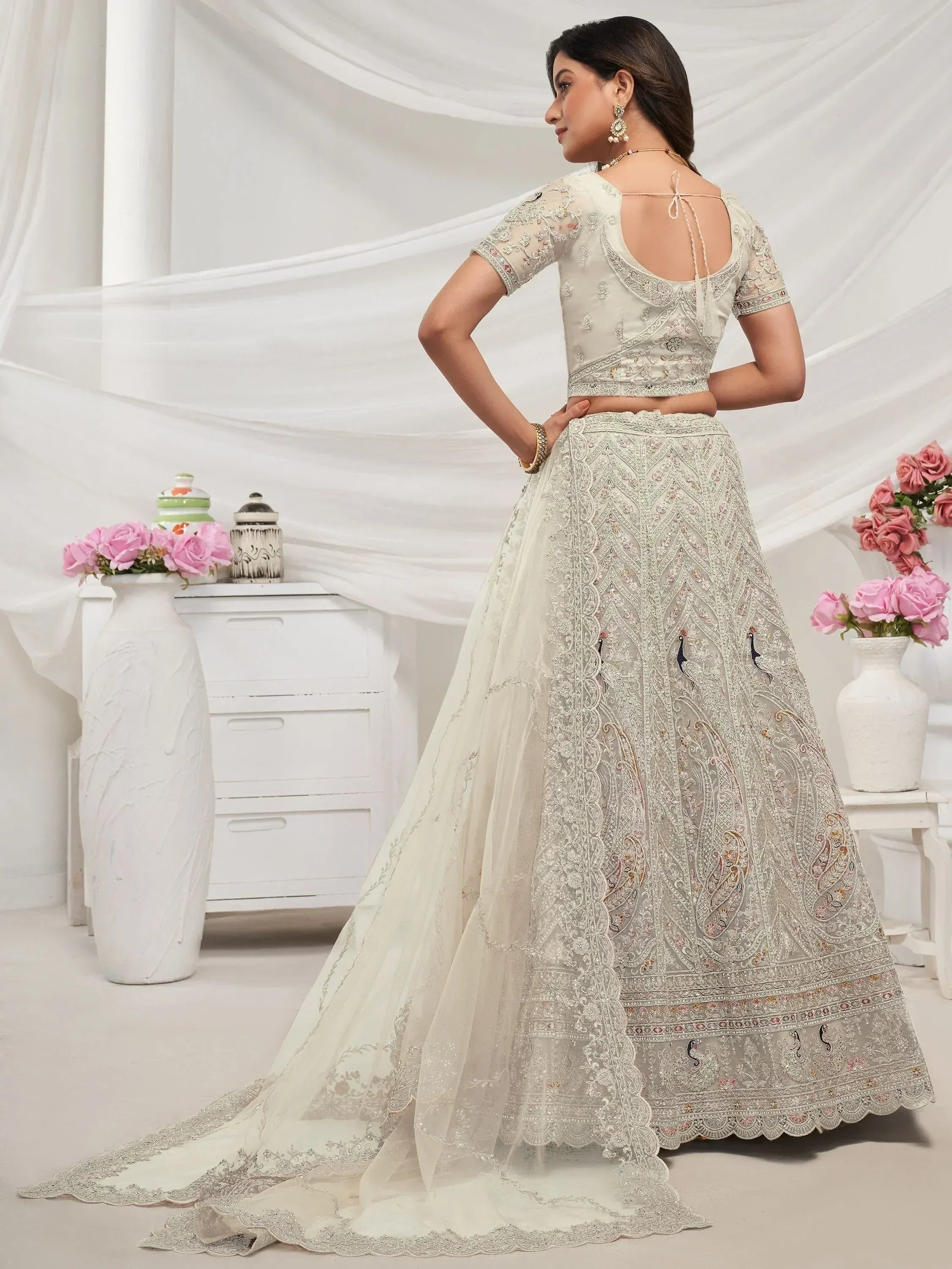 Elegant off-white lehenga choli with intricate embroidery and peacock motifs, perfect for Indian ethnic occasions.