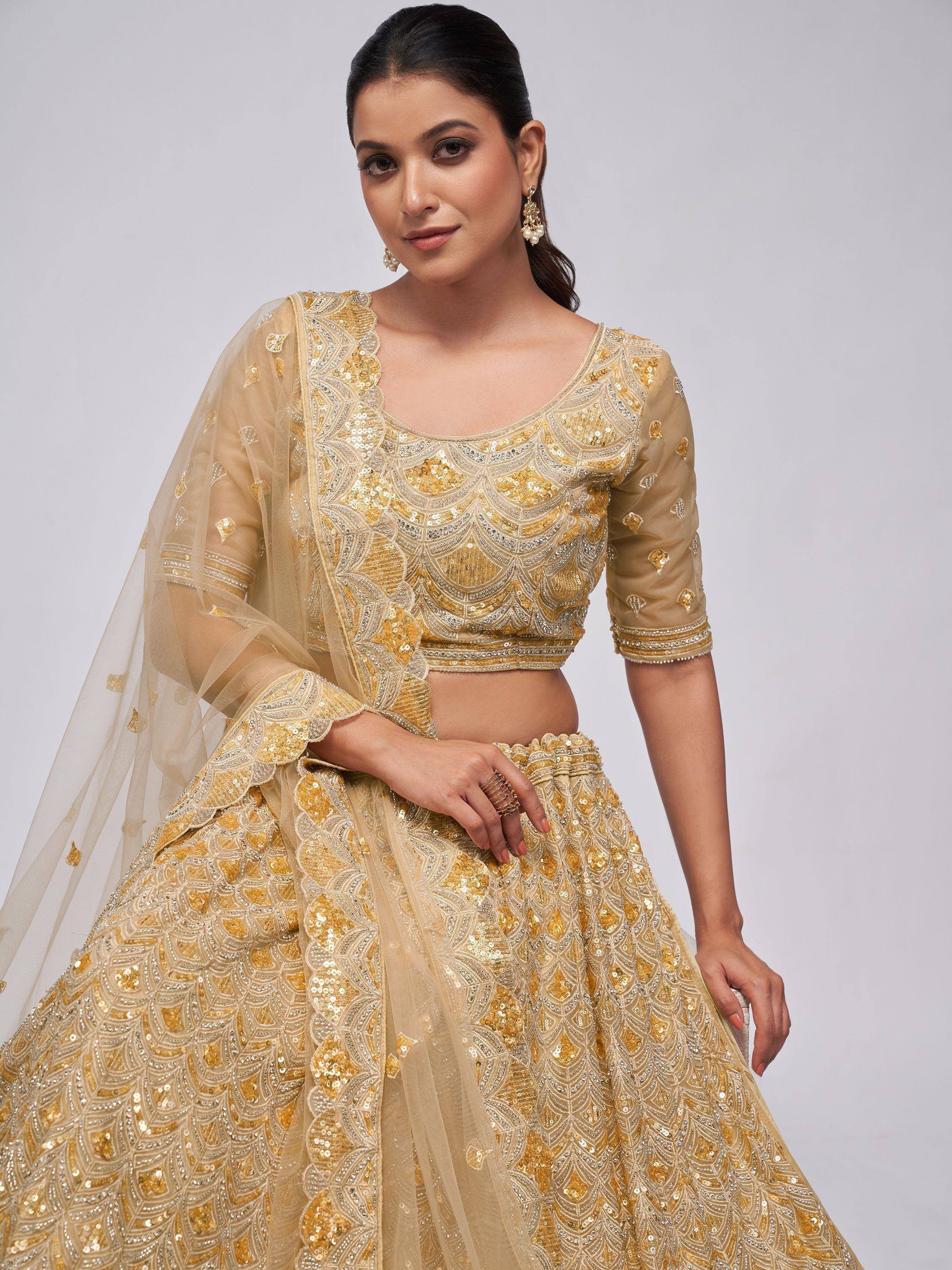 Golden sequin lehenga choli with scalloped blouse and sheer dupatta, perfect for Indian weddings and festive occasions.