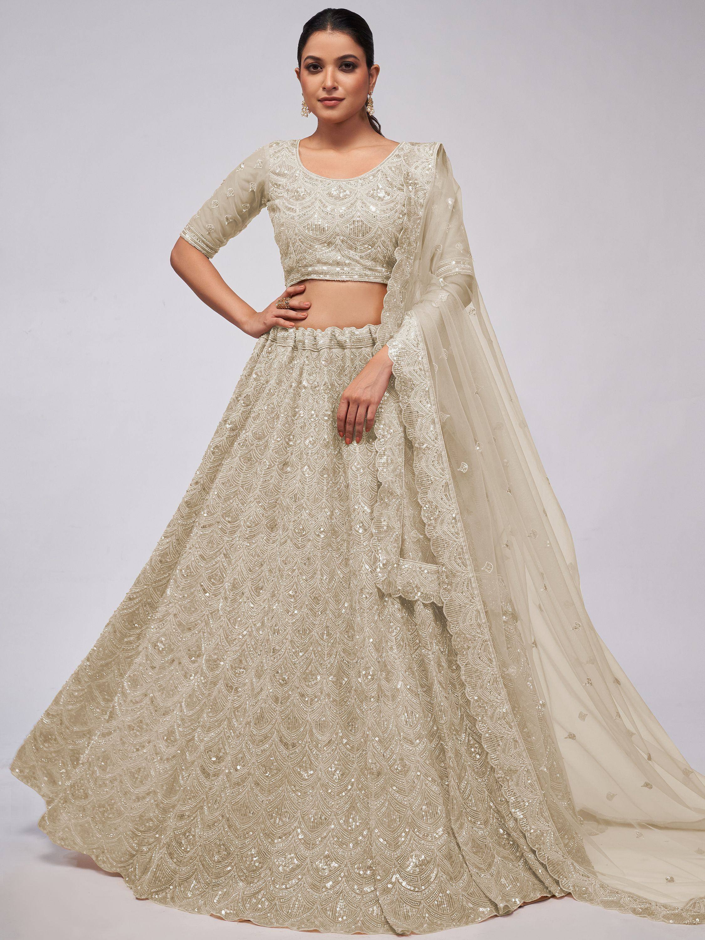 Elegant ivory lehenga choli with intricate sequin embroidery and sheer dupatta, perfect for Indian weddings and festive occasions.