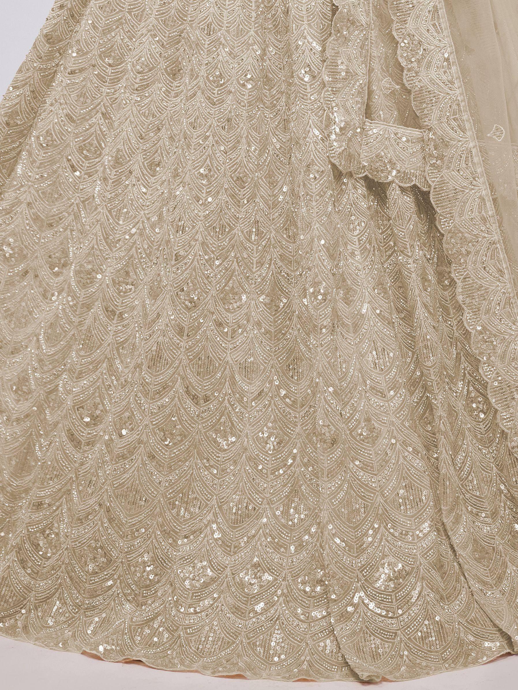 Beige sequin-embellished lehenga with intricate feather-like patterns, perfect for Indian ethnic wear.