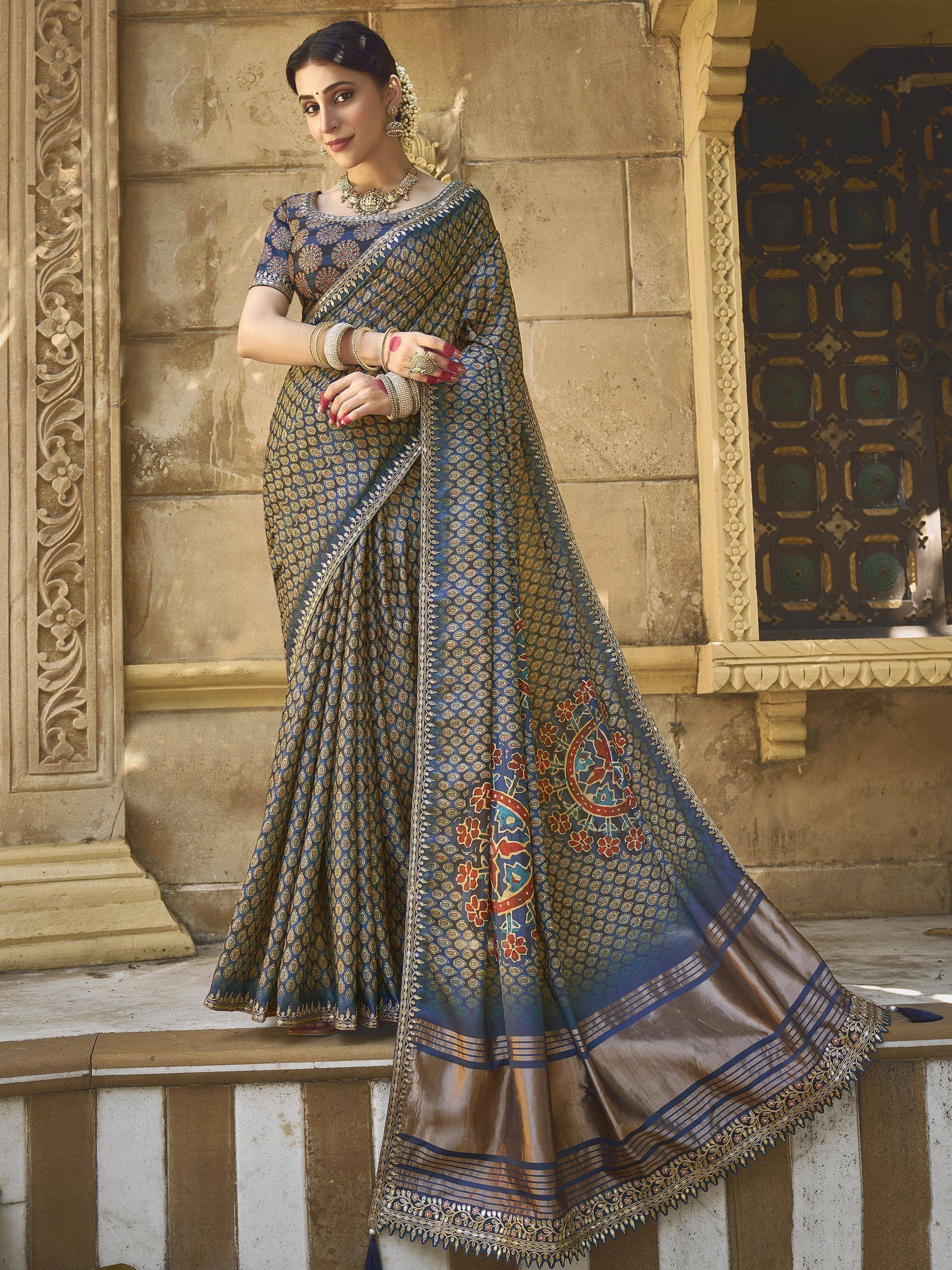 Blue and gold printed saree with intricate border, styled with traditional jewelry for ethnic wear