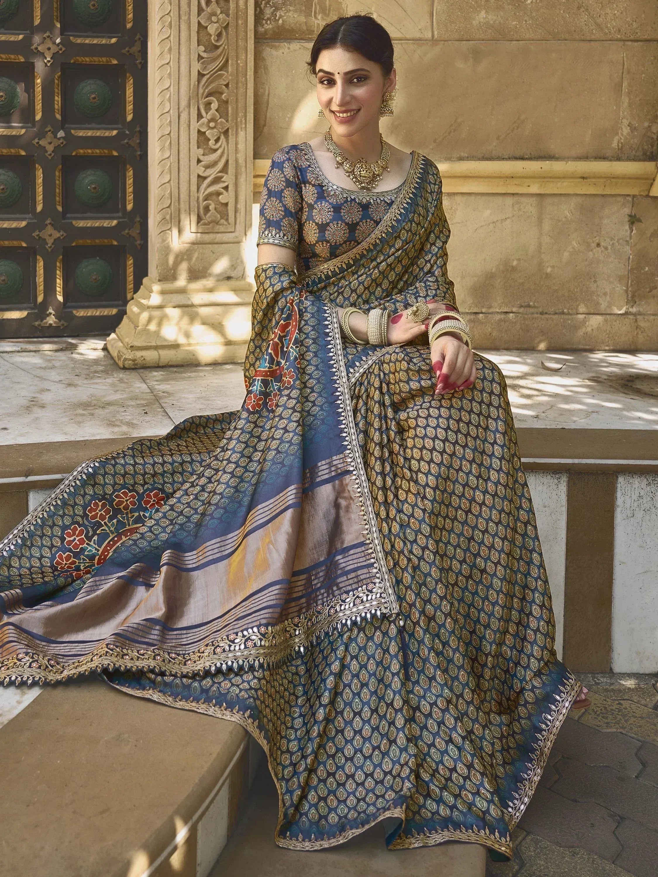 Woman in blue and gold printed designer lehenga choli with intricate embroidery, traditional Indian ethnic wear
