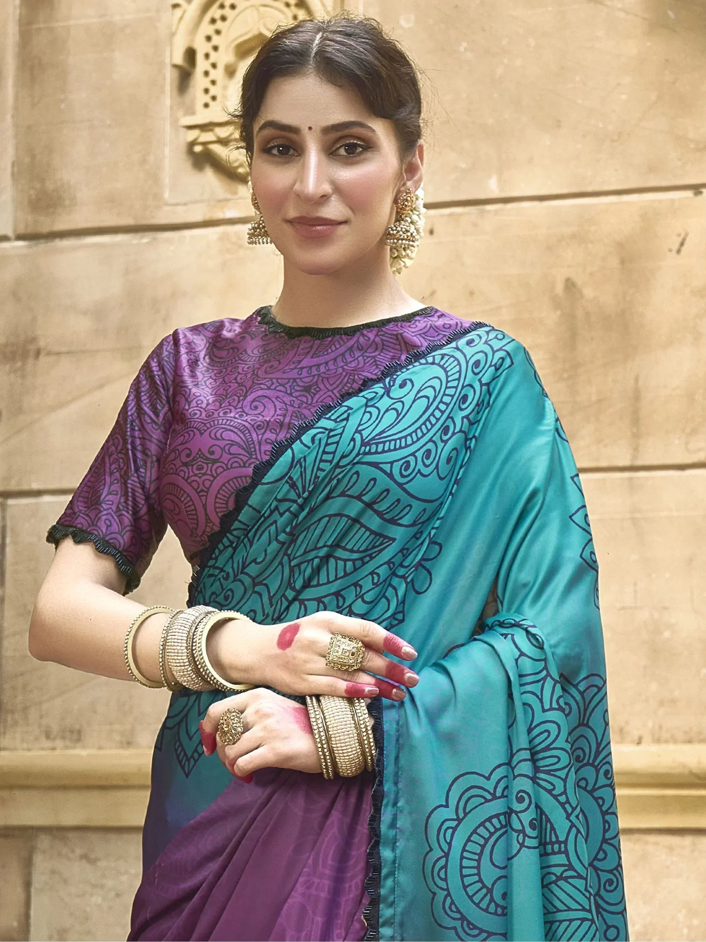 Woman in purple and teal printed saree with ethnic jewelry, ideal for Indian ethnic wear occasions