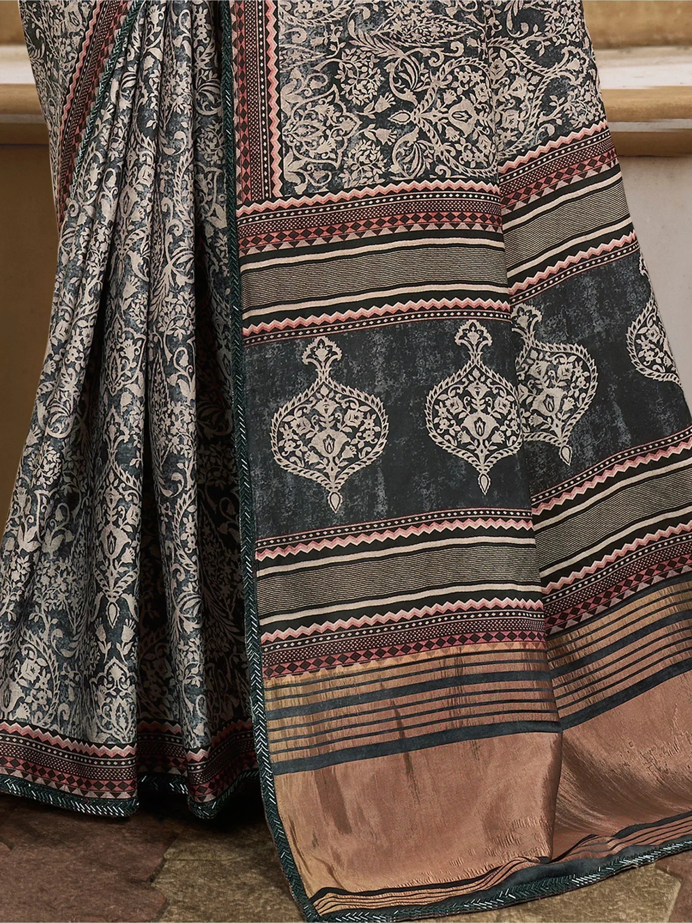 Black and gold ethnic saree with intricate floral and geometric prints, perfect for traditional Indian wear.