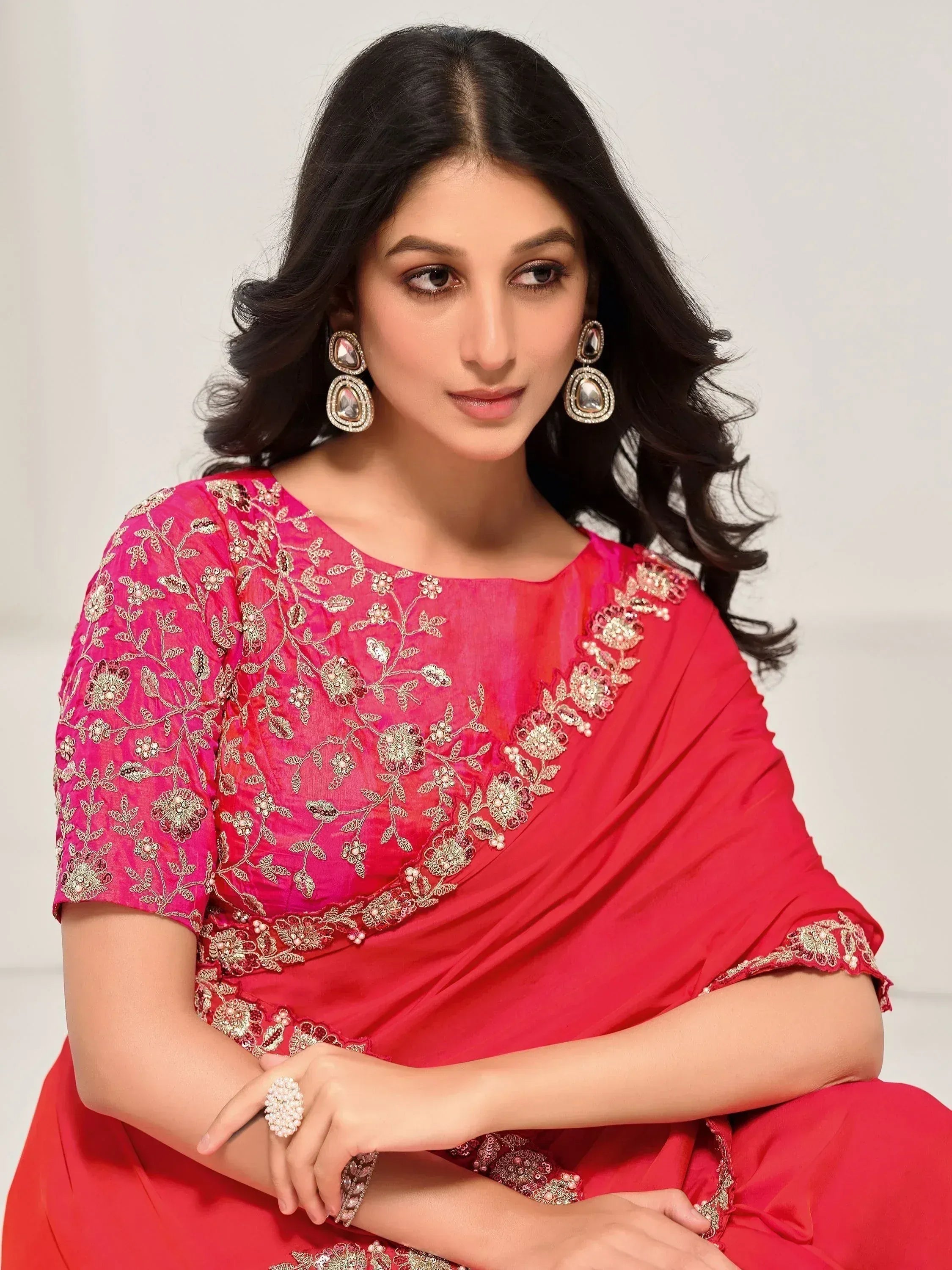 Woman in vibrant red ethnic saree with gold floral embroidery and statement earrings