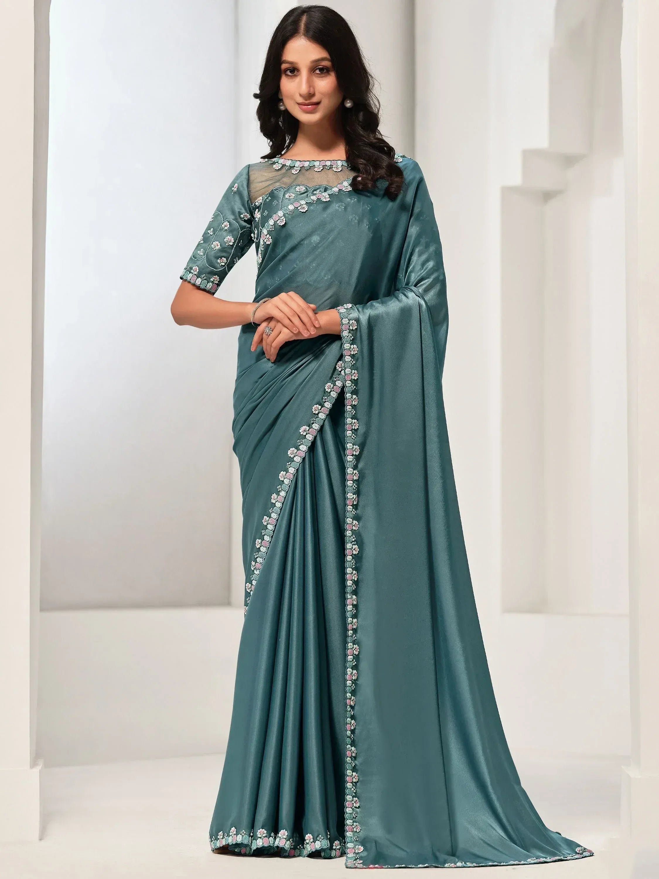 Teal saree with floral embroidery, sheer neckline, and elegant drape for Indian ethnic wear