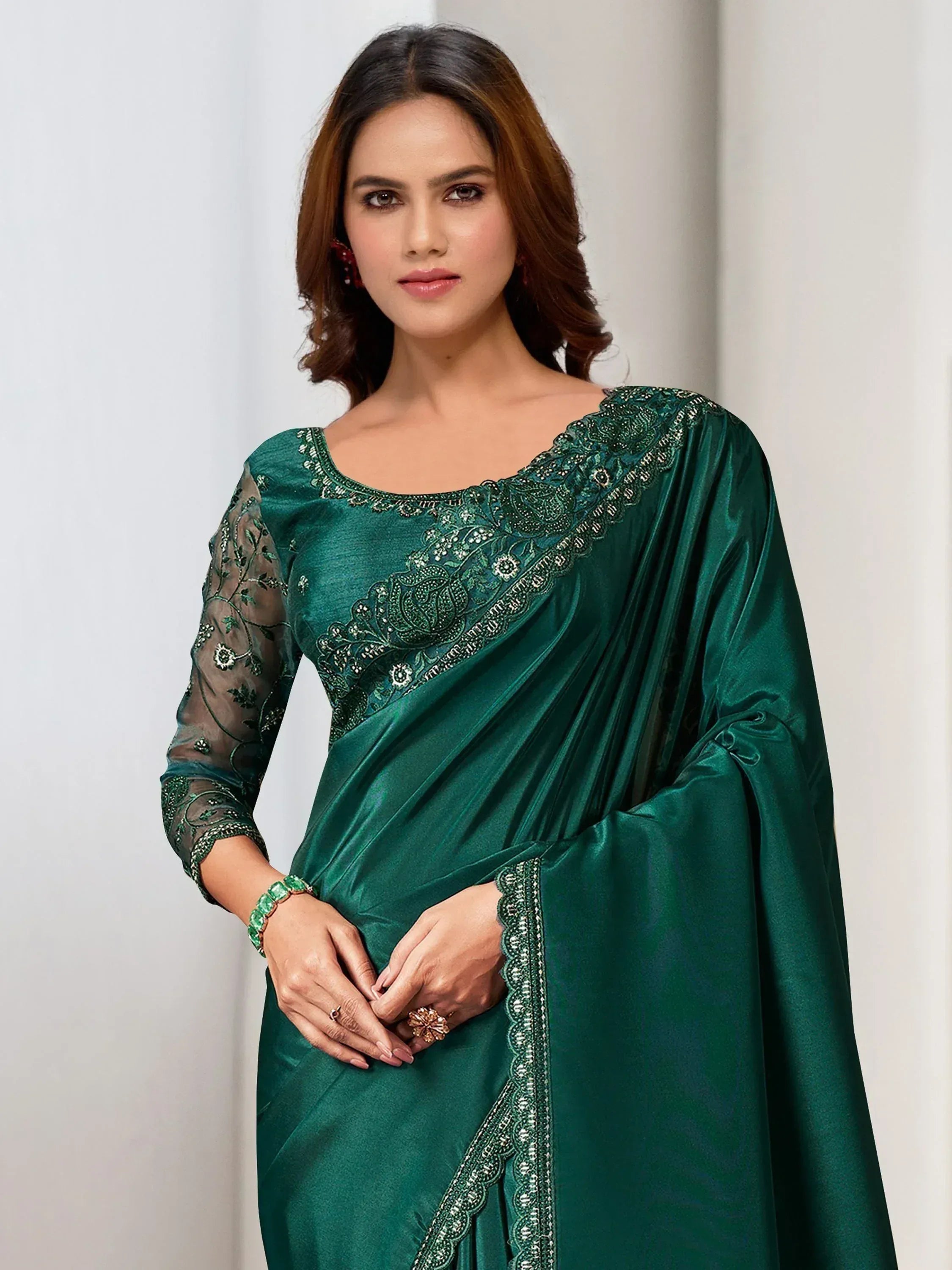 Emerald green designer saree with intricate embroidery and sheer sleeves, perfect for ethnic occasions.