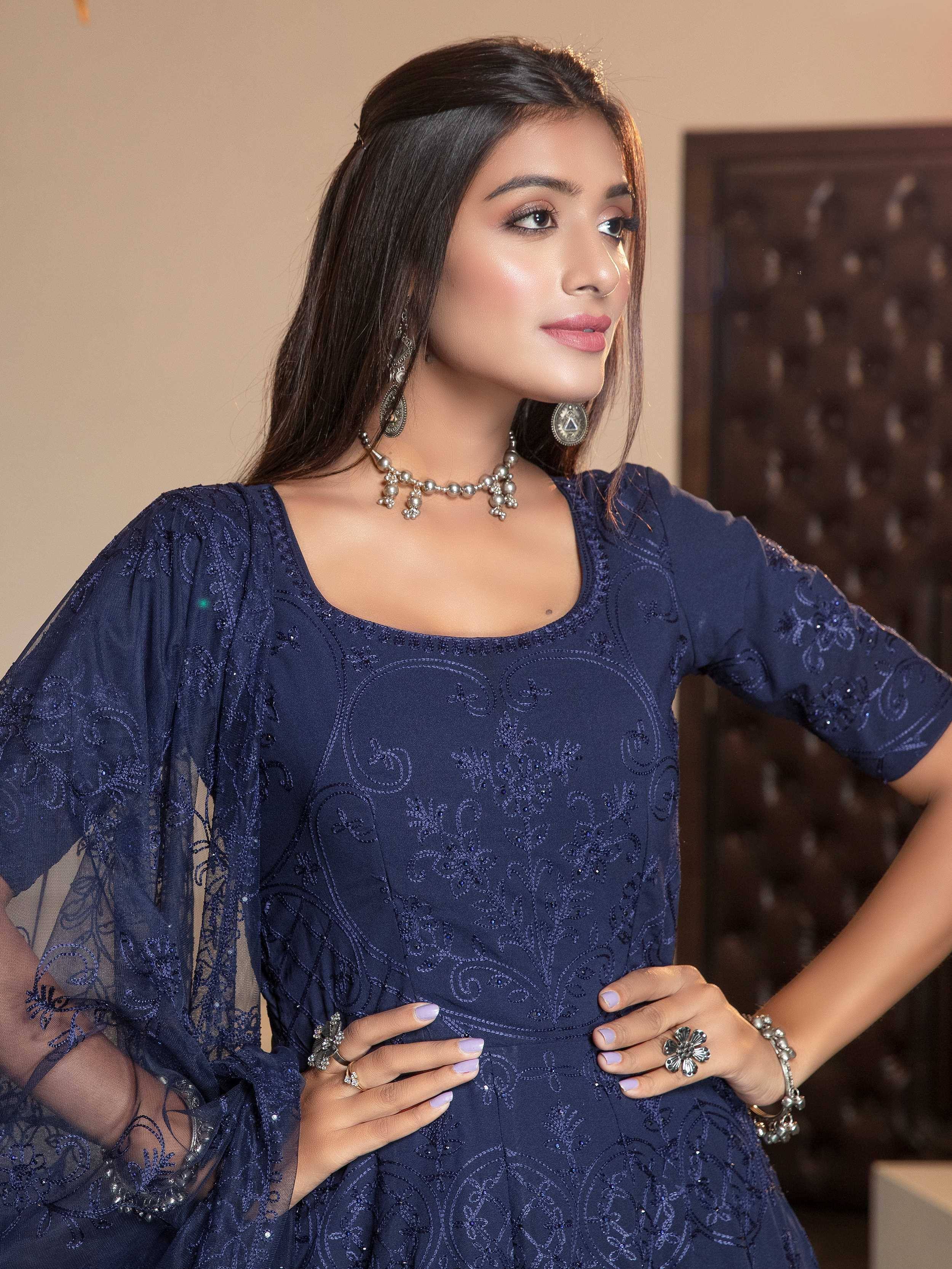 Navy blue embroidered ethnic gown with sheer sleeves, paired with traditional jewelry for festive occasions