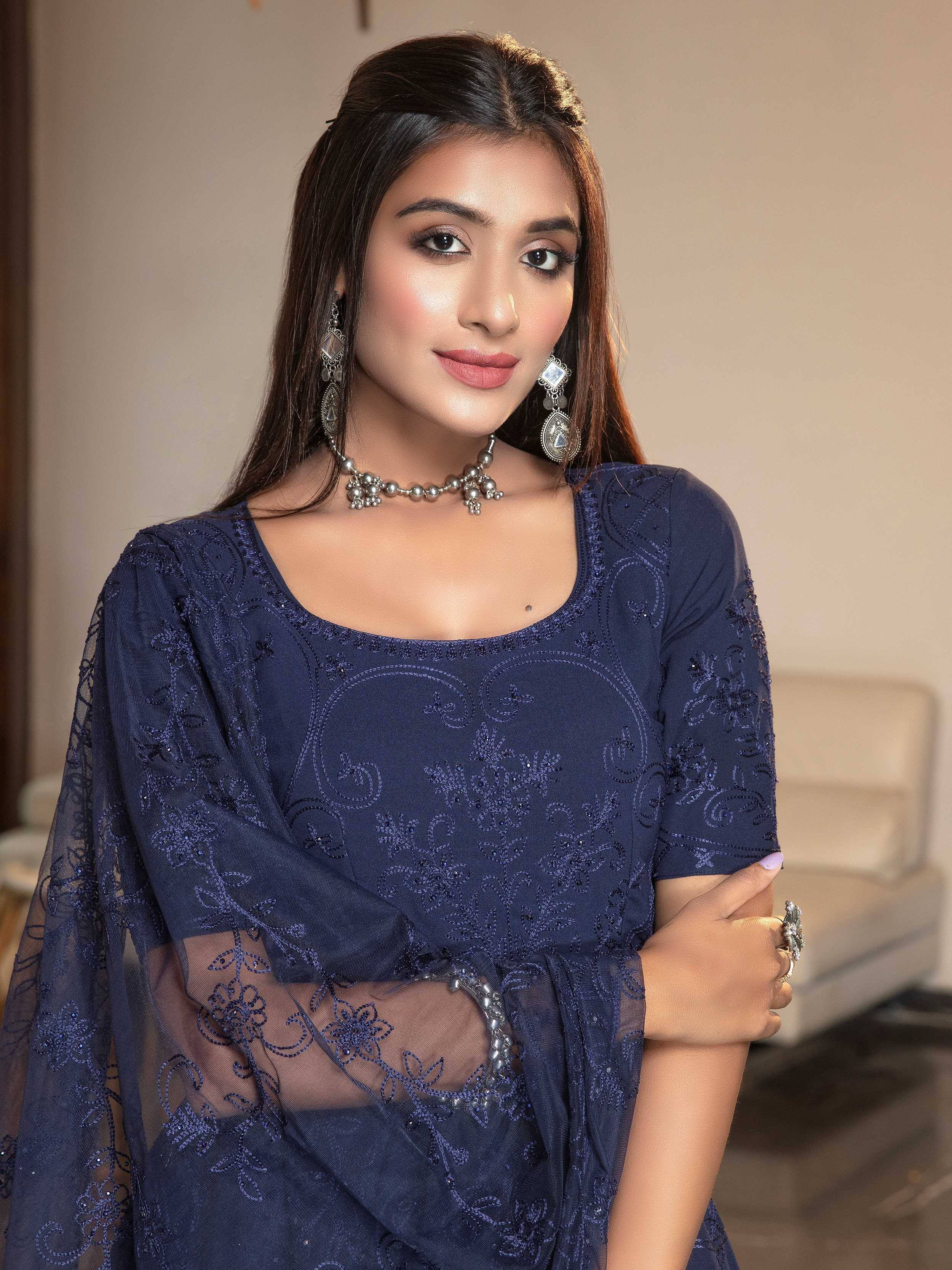Navy blue embroidered ethnic gown with sheer sleeves, paired with traditional jewelry for festive occasions