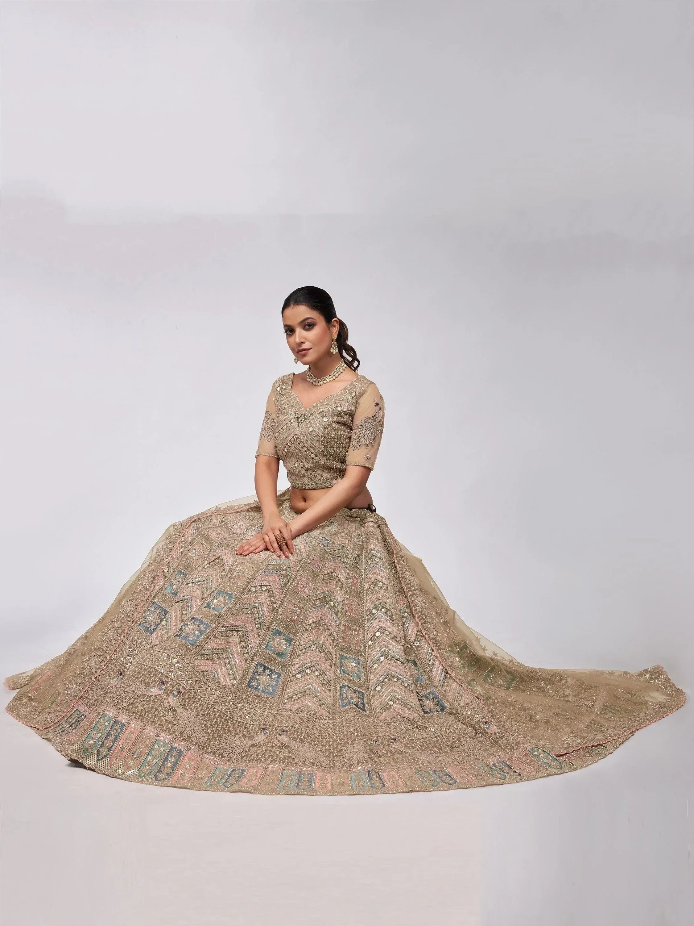 Elegant beige lehenga choli with intricate geometric embroidery and peacock motifs, perfect for Indian weddings and festive occasions.