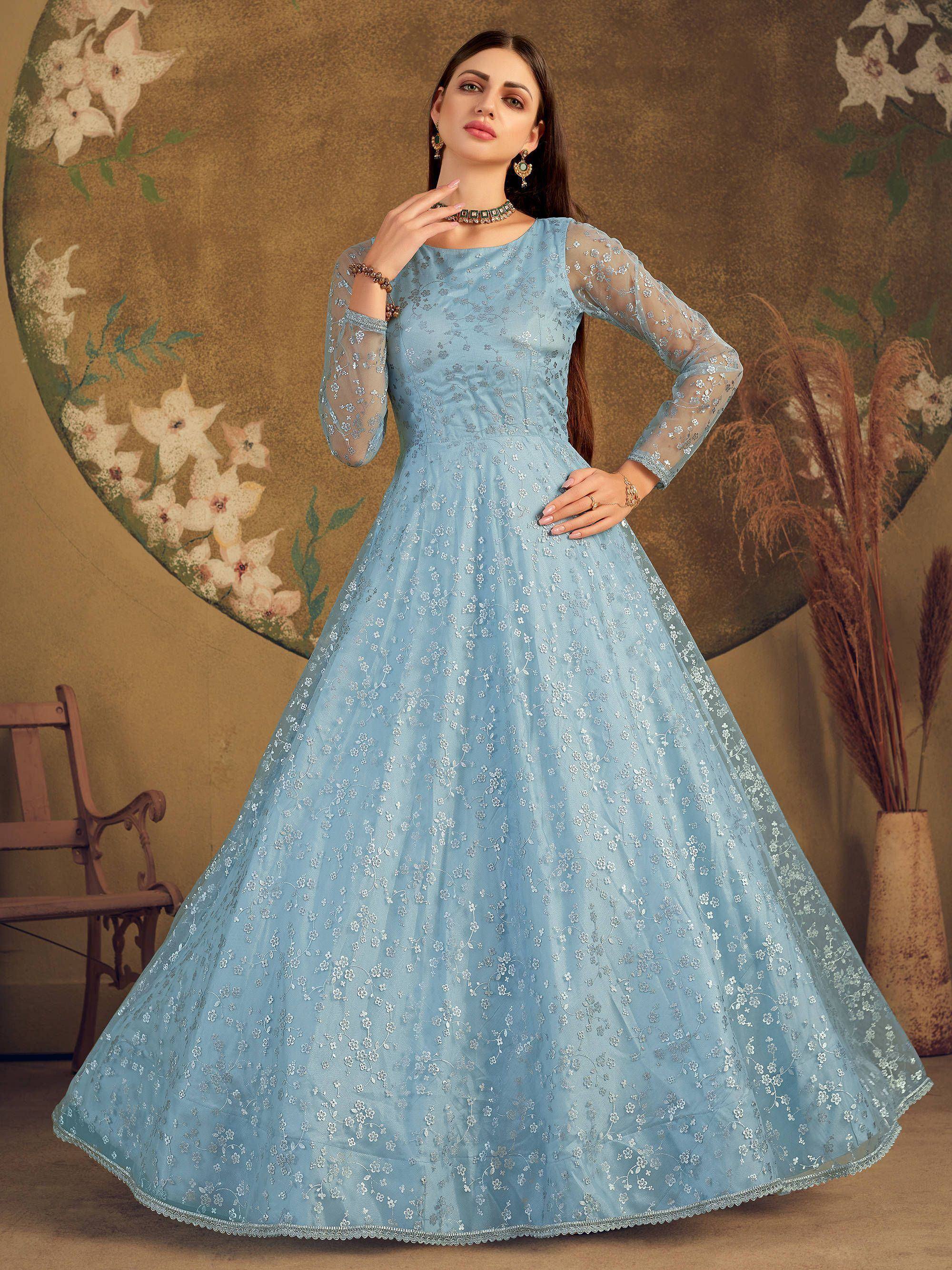 Woman wearing a light blue embroidered ethnic gown with sheer sleeves, floral background
