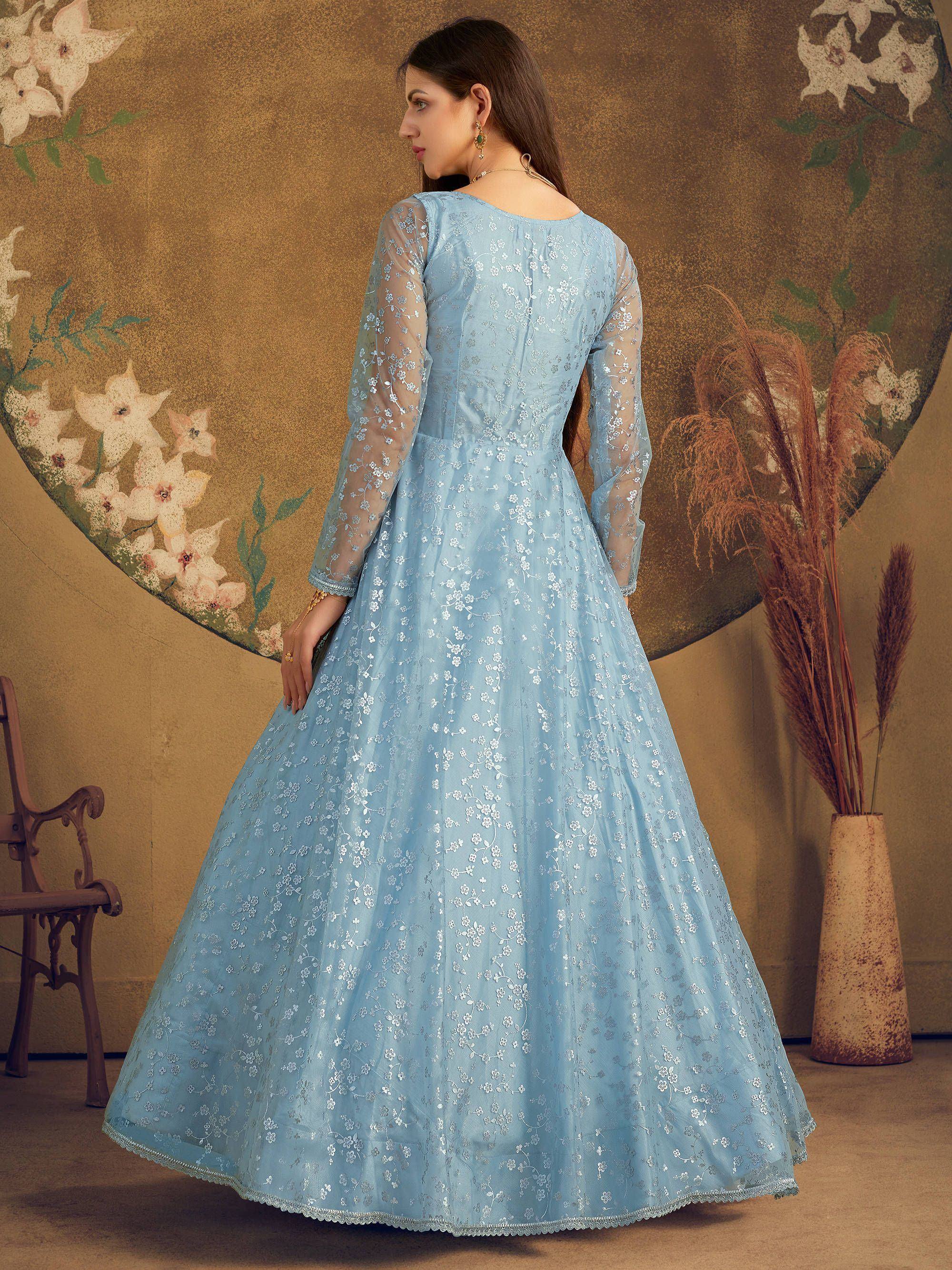 Woman in pastel blue embroidered ethnic gown with sheer sleeves, floral backdrop