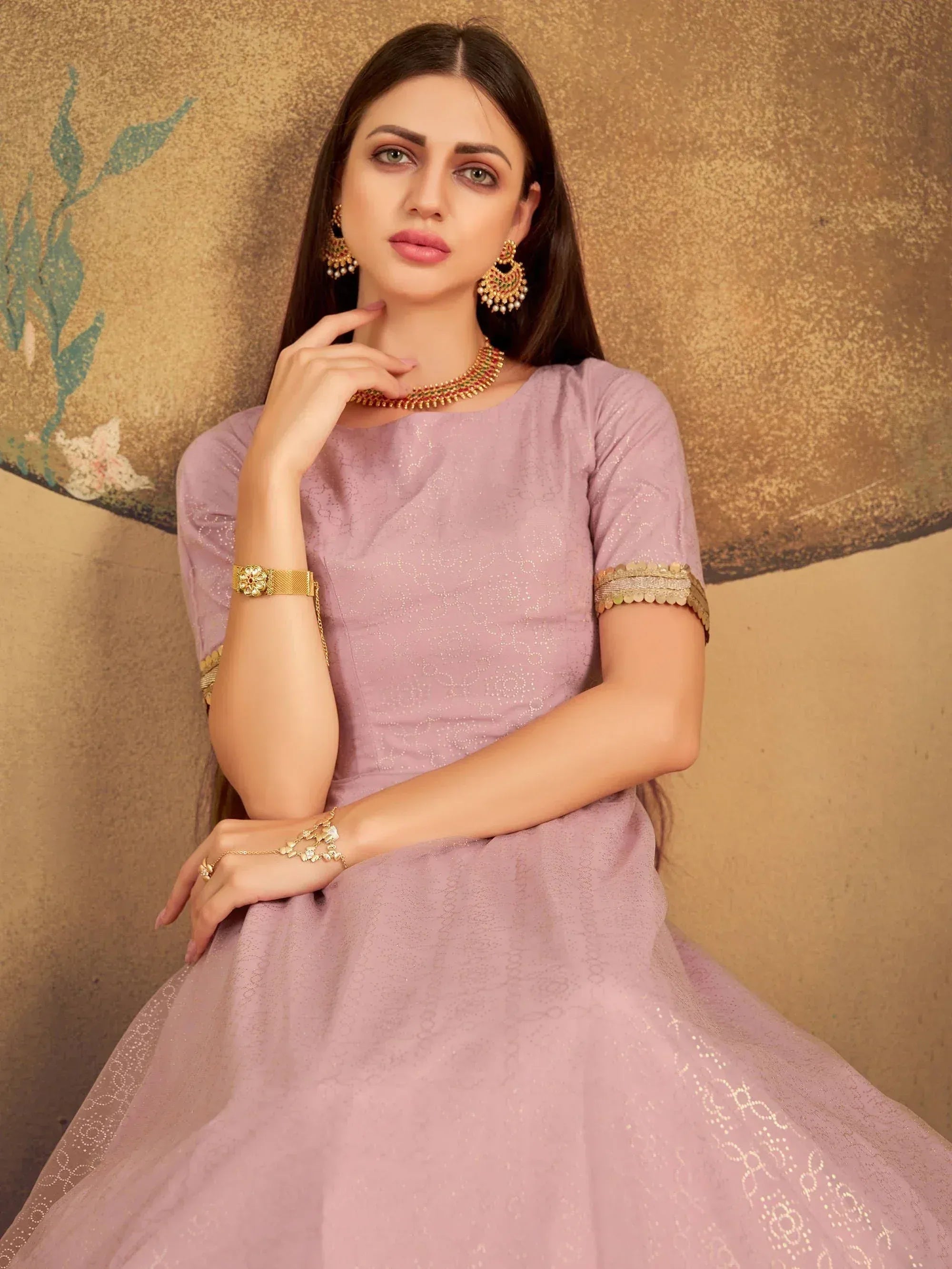 Elegant lavender ethnic gown with gold embroidery, paired with traditional jewelry for festive occasions