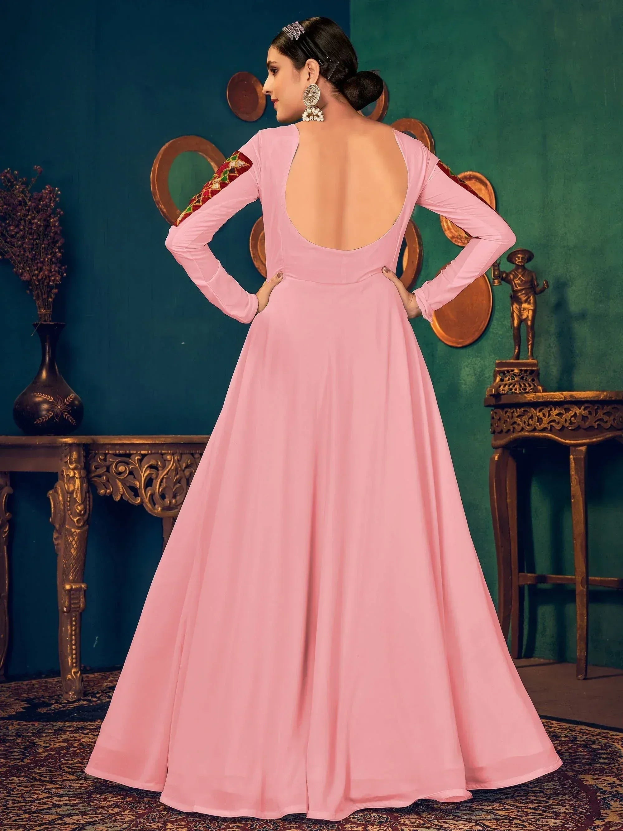 Pink ethnic gown with backless design and embroidered sleeves, perfect for Indian occasions
