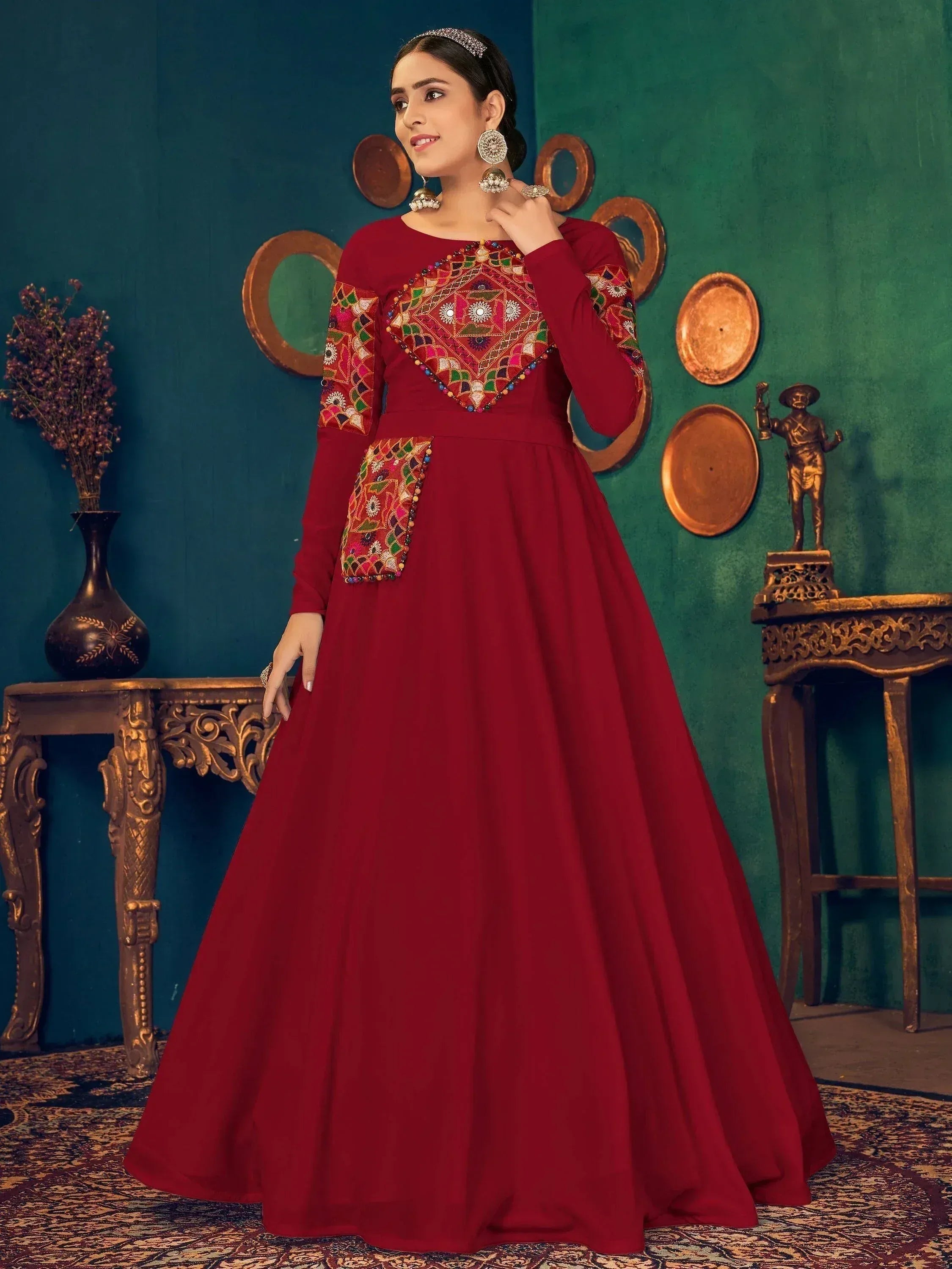 Red ethnic gown with colorful mirror work and long sleeves, perfect for Indian festive occasions