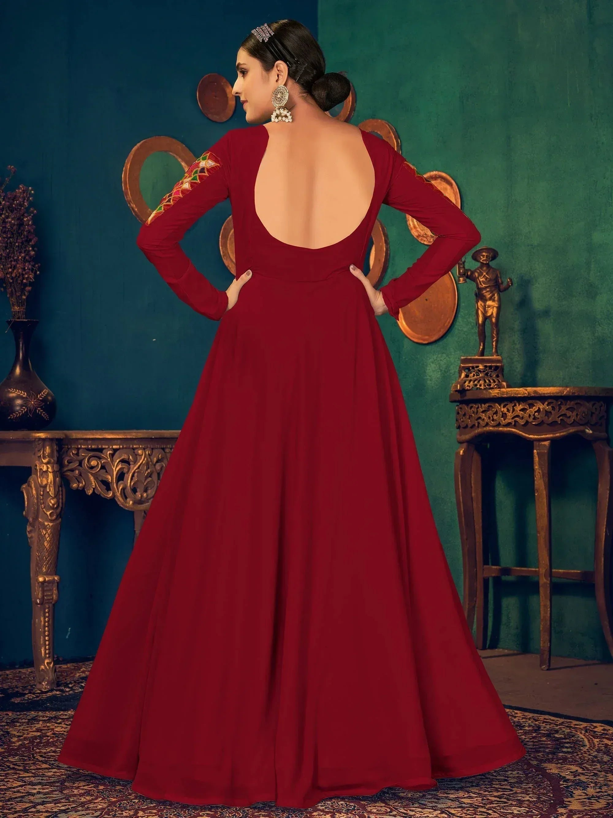 Red ethnic gown with backless design and embroidered sleeves, perfect for Indian occasions