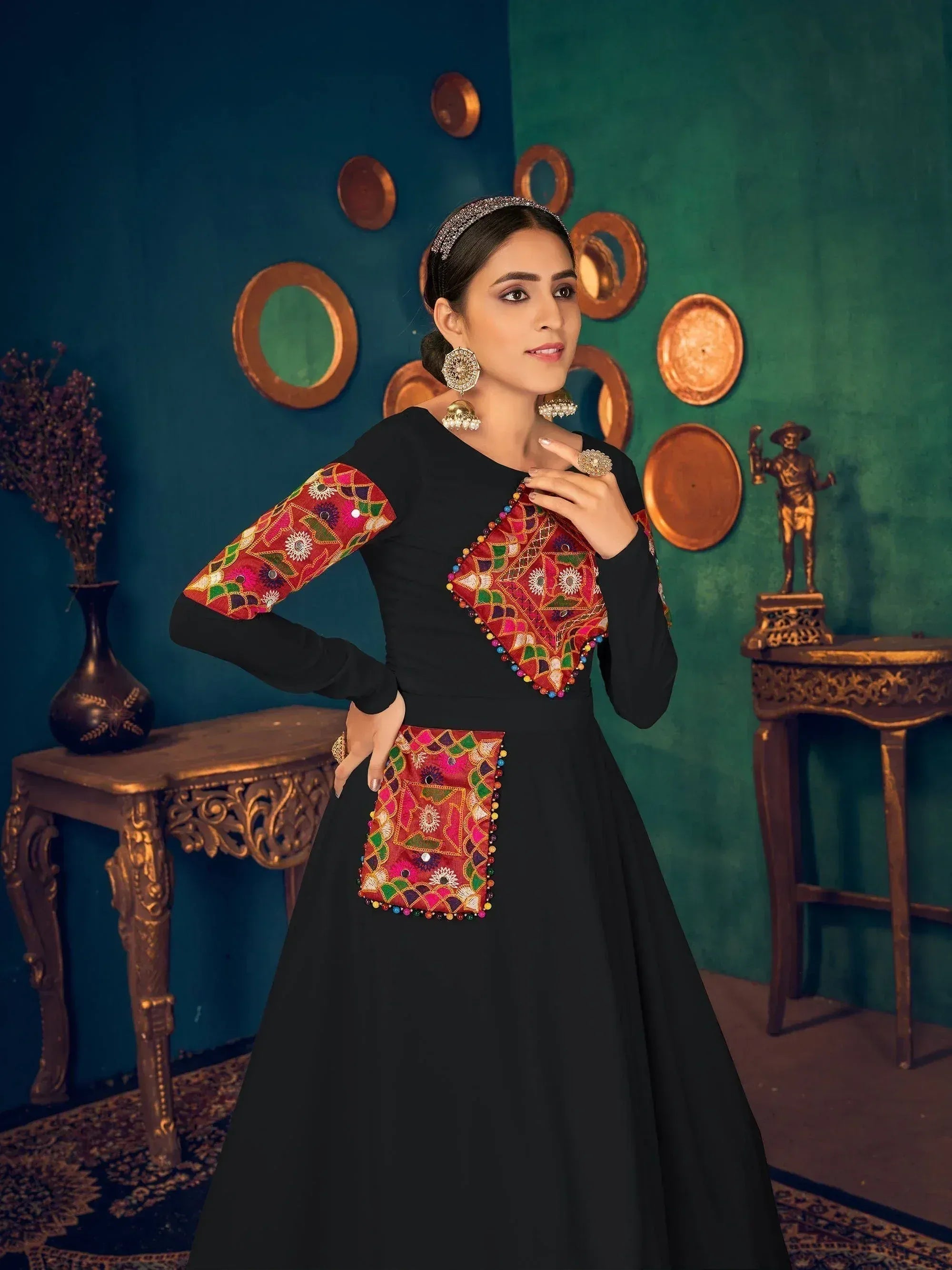 Black ethnic gown with vibrant embroidered panels and mirror work, perfect for Indian festive occasions.