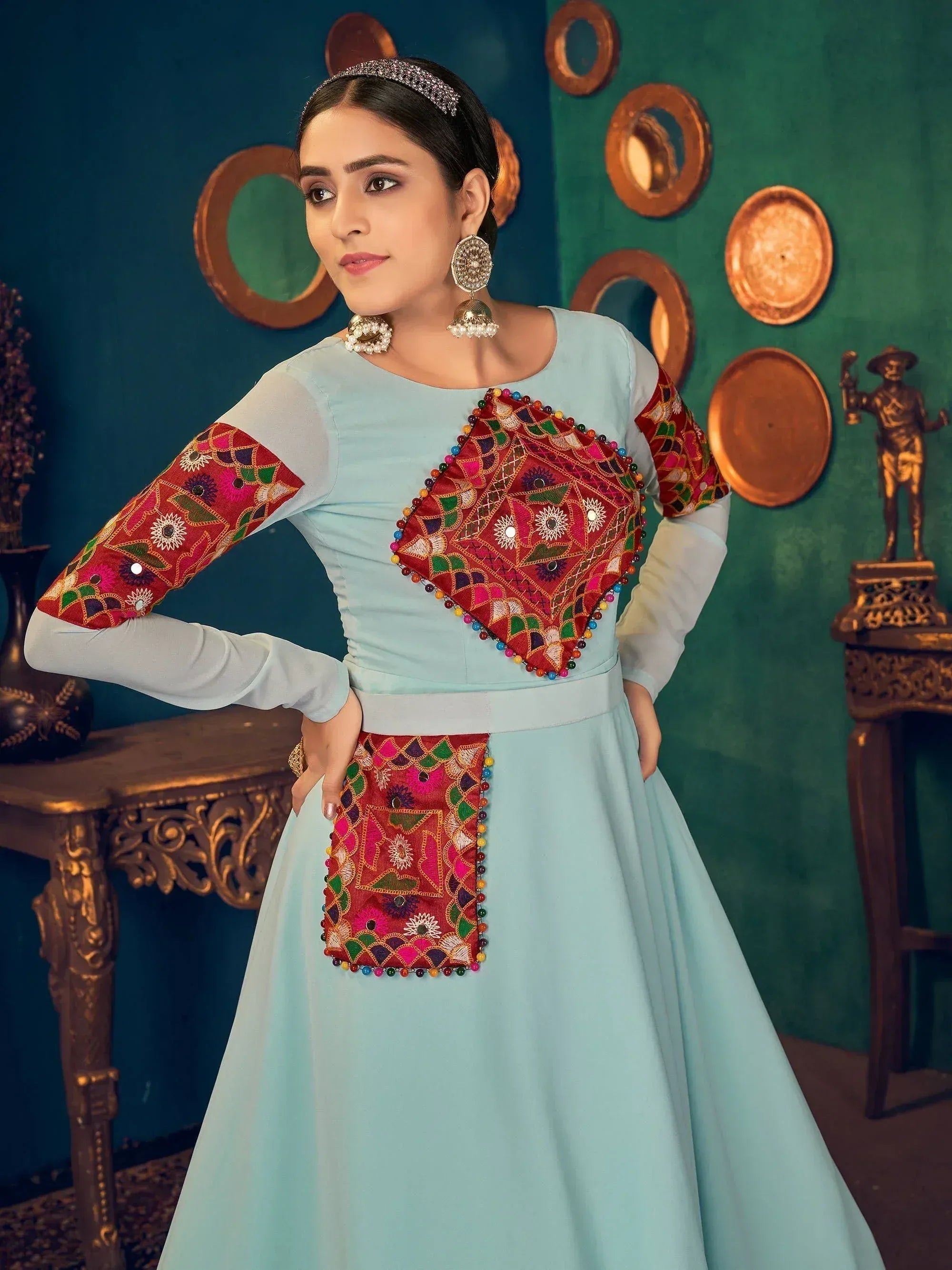 Light blue ethnic gown with vibrant red mirror work and floral embroidery, perfect for Indian festive occasions.