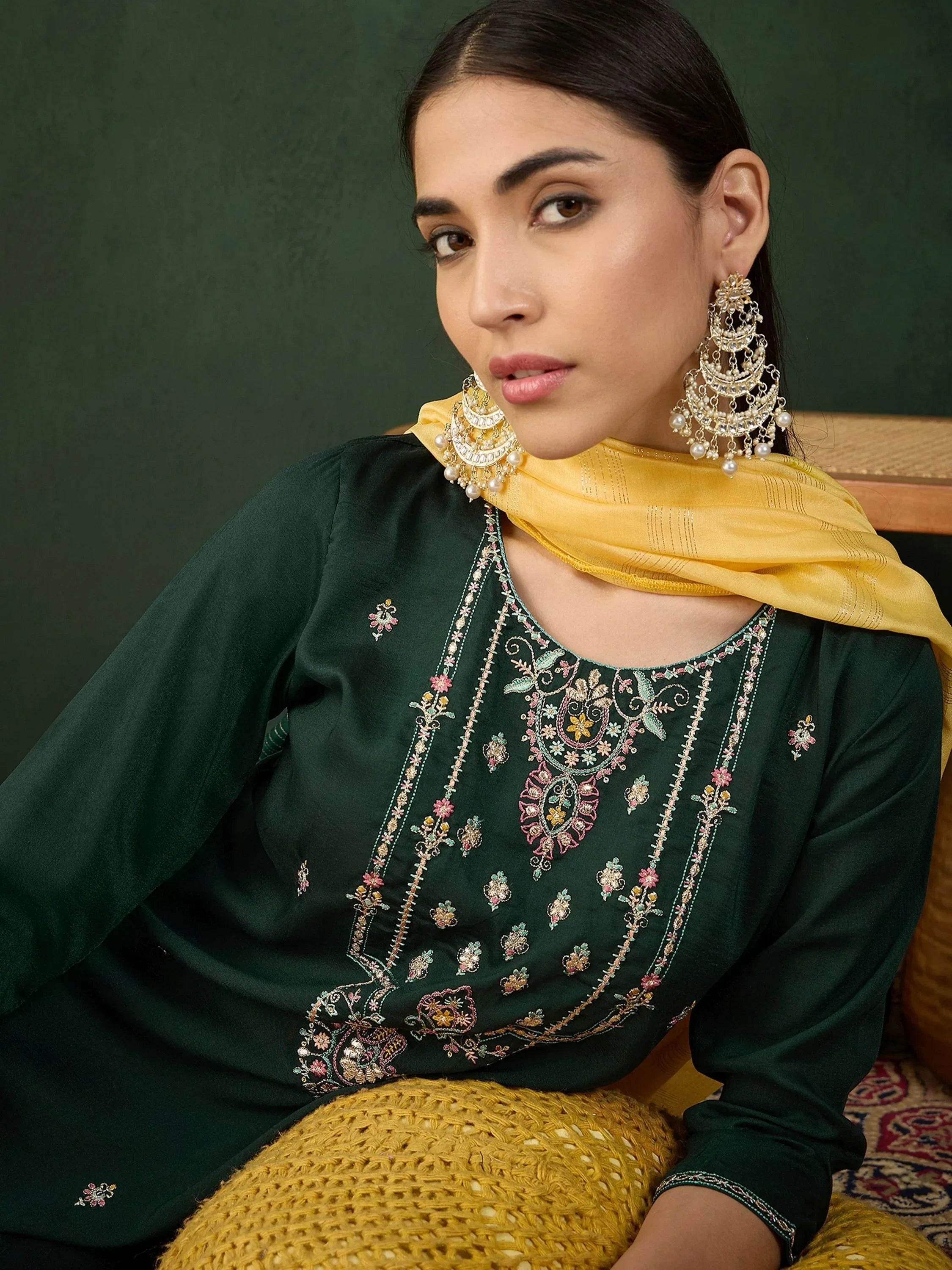 Woman in green embroidered kurta with yellow dupatta and statement earrings